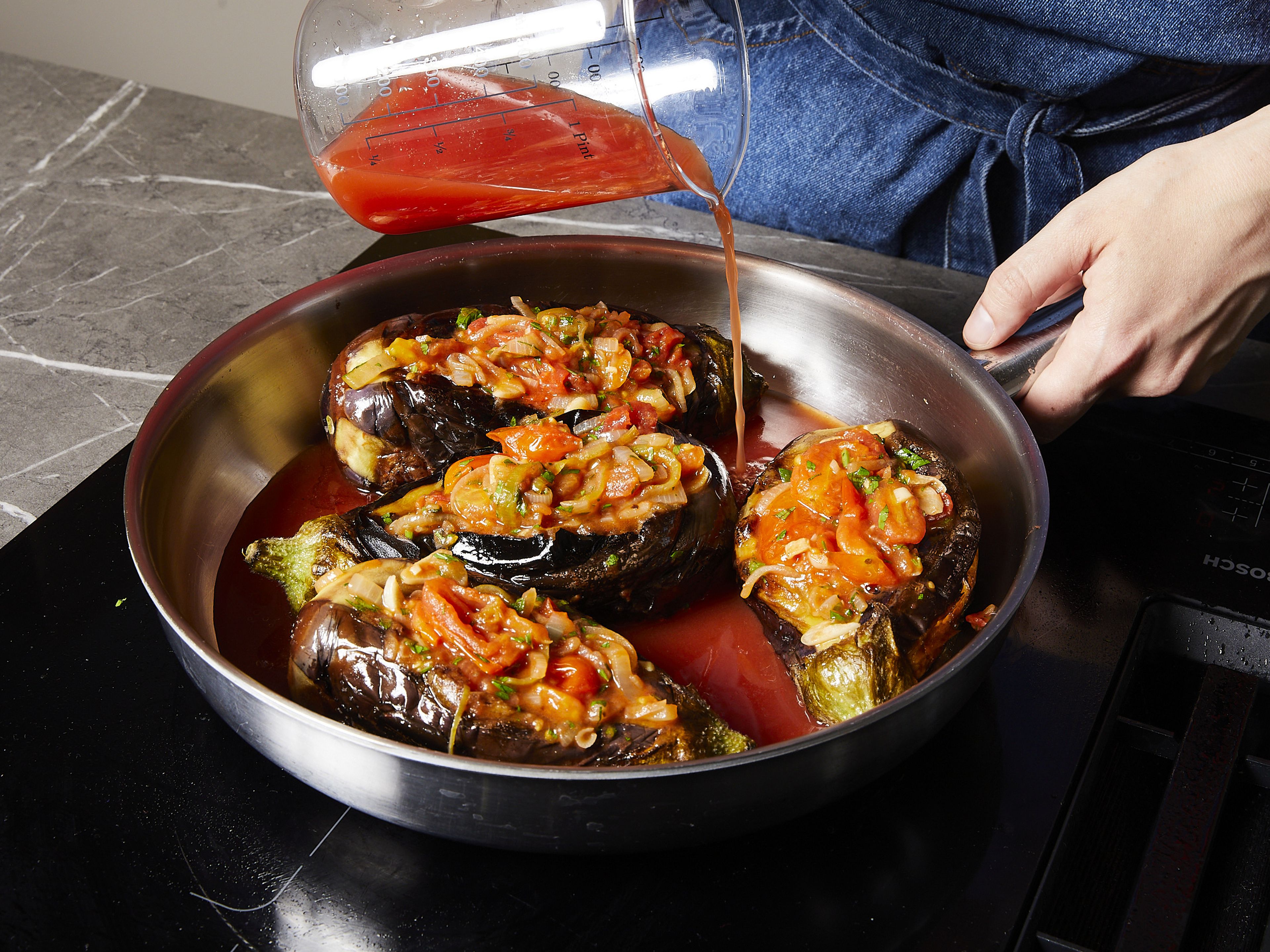 Mix the tomato purée, sugar, water, and a little salt and pepper and add to the pan with the eggplants. Cook over a low heat with the lid on for approx. 35 mins. until the eggplants are completely soft and the flesh is translucent. If necessary, add a little more liquid if it looks too dry. Serve with extra parsley, yogurt and flatbread.