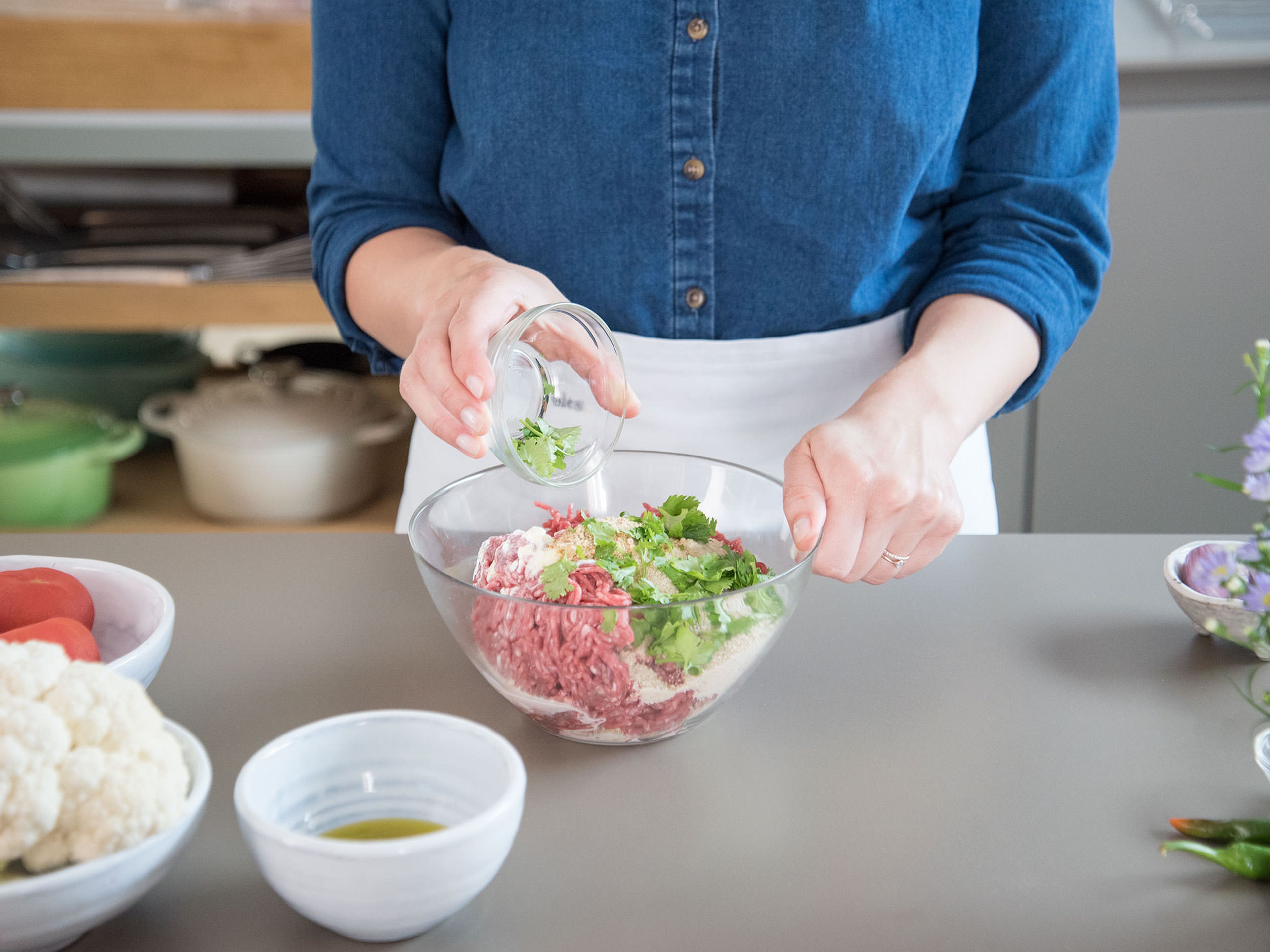 In the meantime, in a large bowl, mix ground meat with breadcrumbs, cilantro, heavy cream, Asian spice mix, and salt. Form 8 equal-sized meat rolls from the mixture and brush with some olive oil. Cover with plastic wrap. Let rest for approx. 30 min. in the fridge.