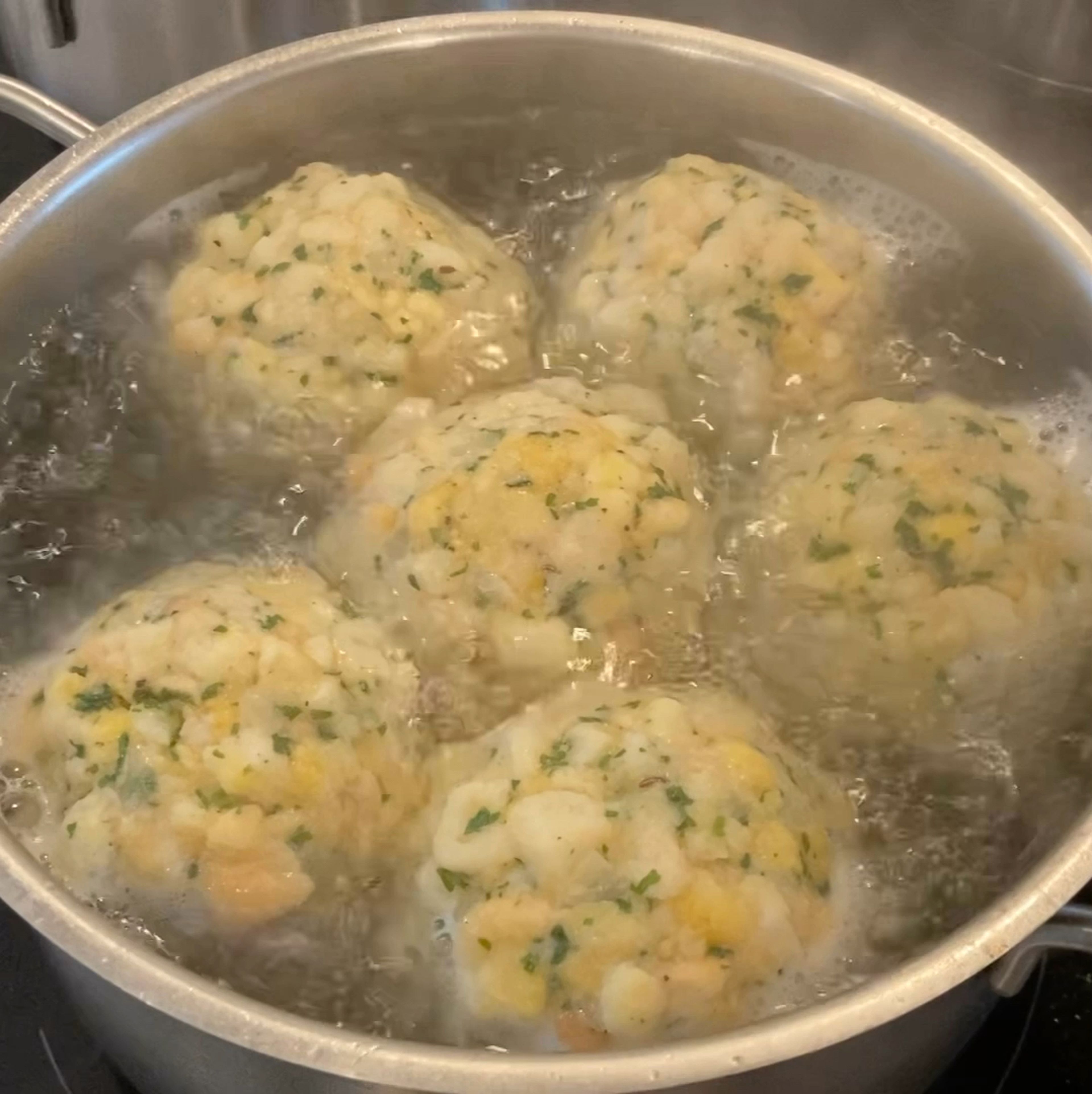die Knödel in einen großen Topf mit leicht gesalzenem Wasser geben, kurz aufkochen und für 15-20min, je nach Größe, simmern lassen, absieben und trocknen lassen. Können nach belieben, auch mit in die Rein gegeben werden