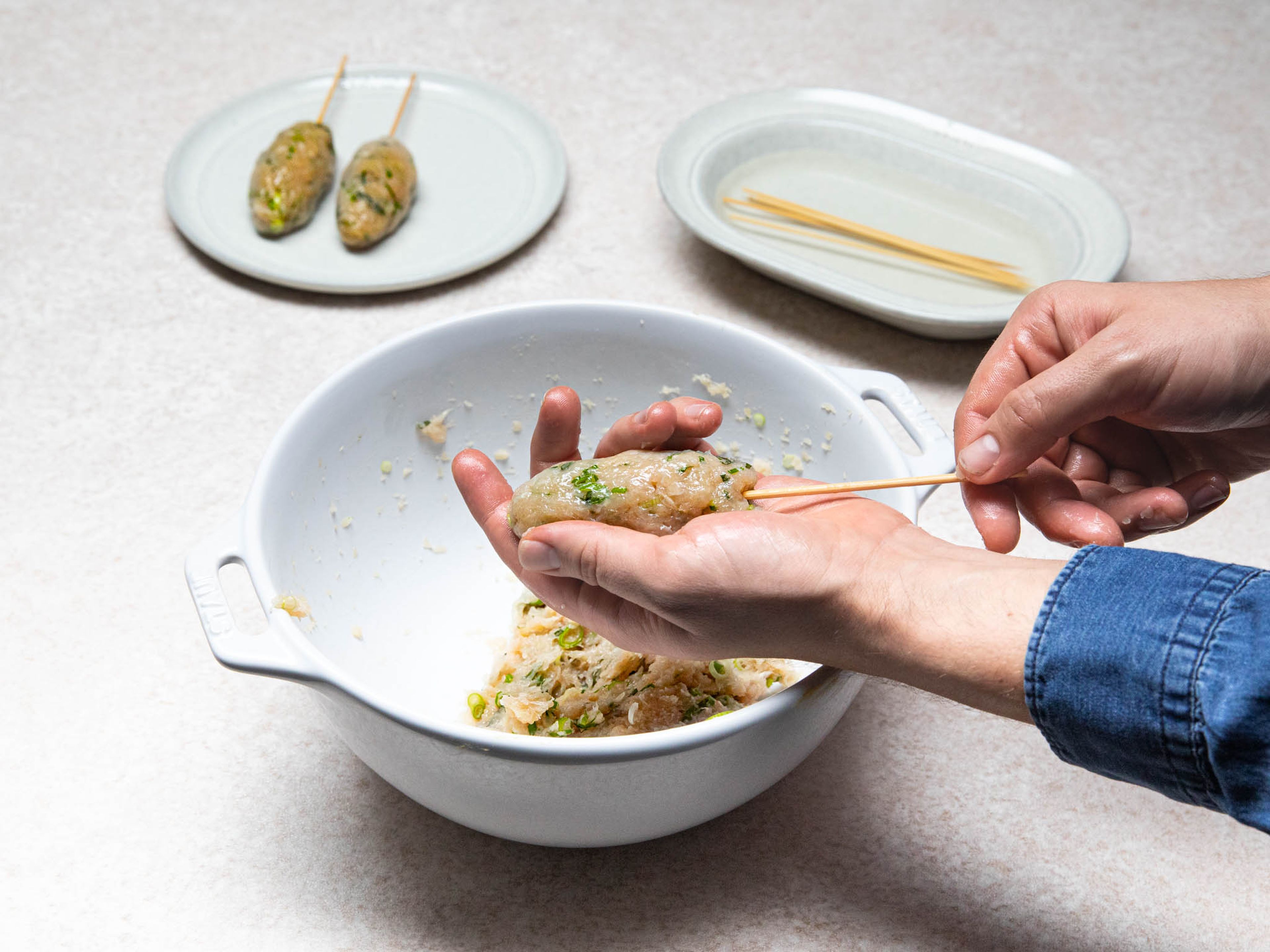 Add chicken, shiso, scallion, miso, and sesame oil to a large bowl. Season with salt and mix to combine. Cover your hands lightly with some sesame oil and shape the meat into a small oval, then skewer with wooden skewers.