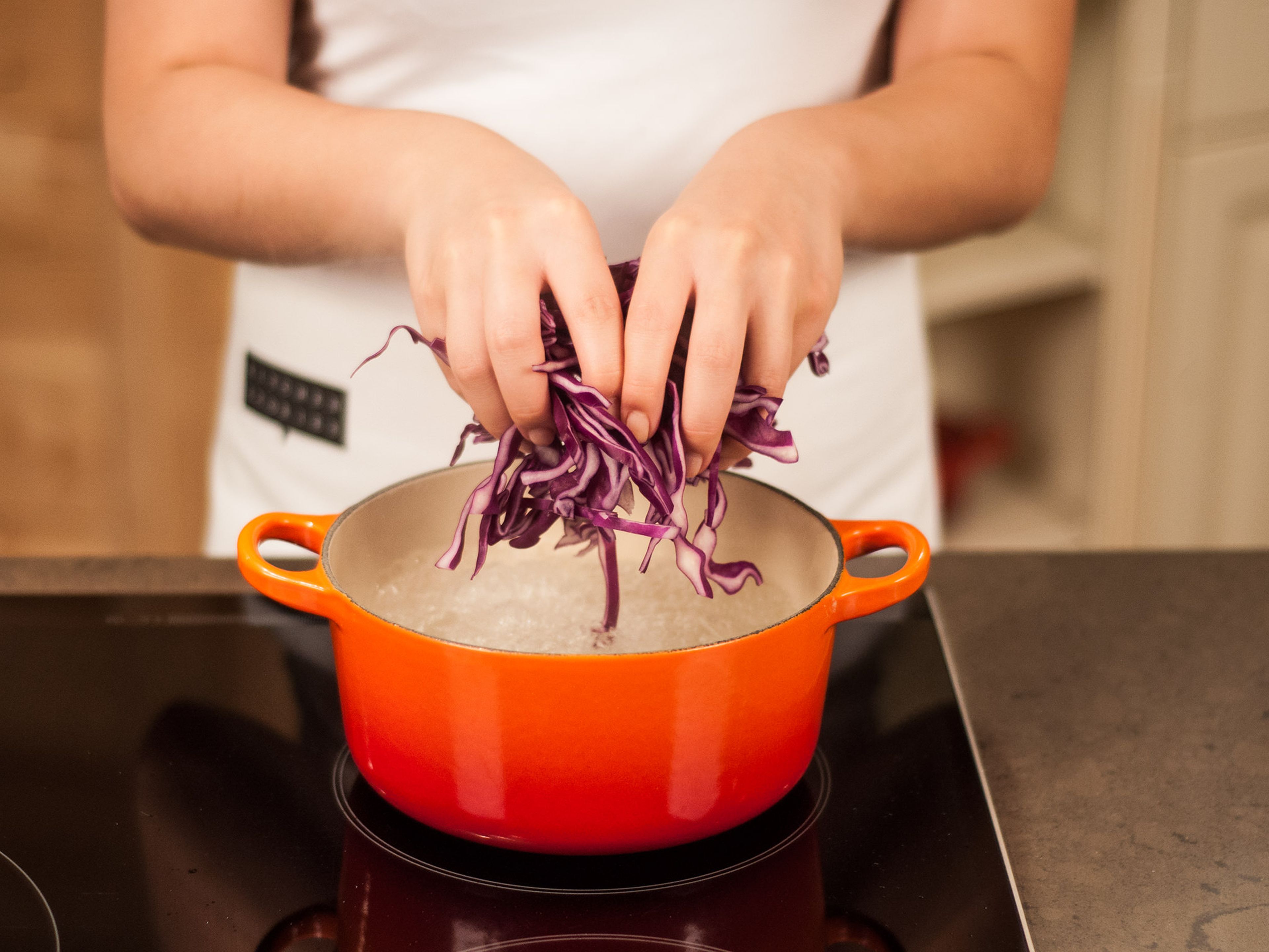Fill half of a large saucepan with water, add some salt, and bring to a boil. Place red cabbage into boiling water and blanch for approx. 3 – 5 min. Then, drain and rinse with cold water.