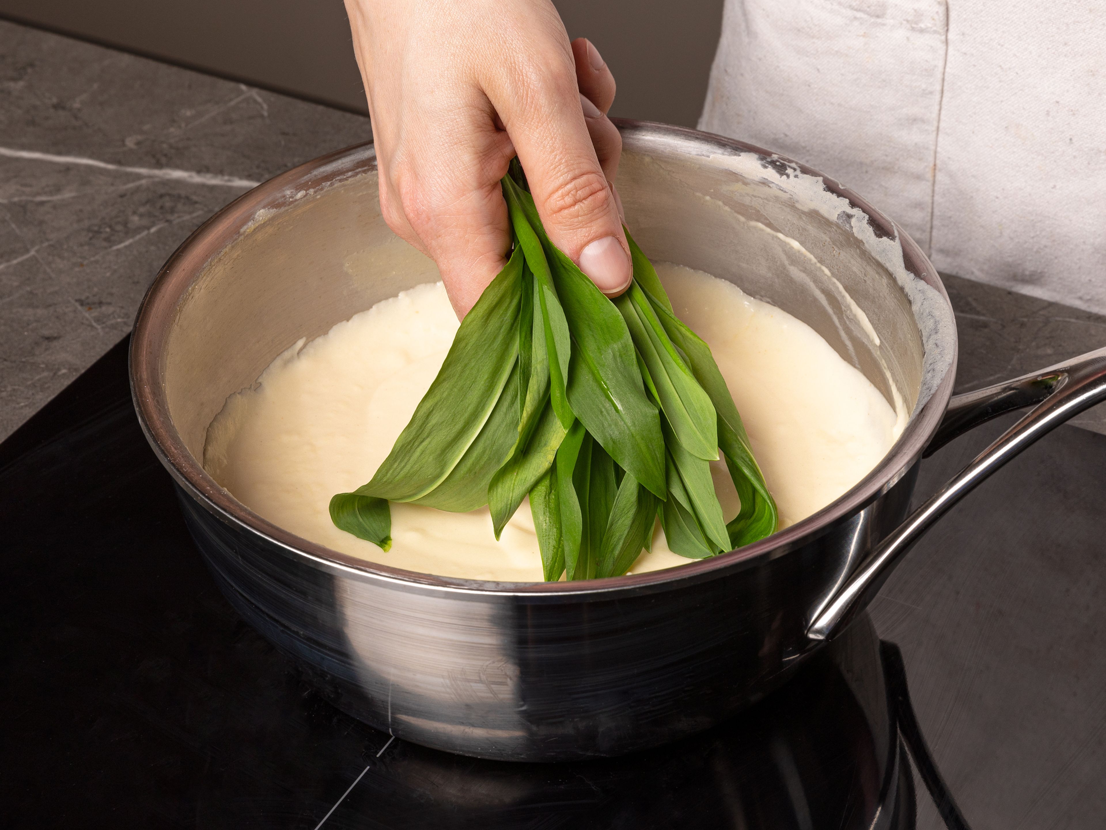 Butter in einem Topf schmelzen, Mehl dazugeben und ca. 1–2 Min. unter Rühren anrösten. Milch und ungesüßte Kondensmilch einrühren. Bei starker Hitze zum Kochen bringen und unter Rühren ca. 1 Min. köcheln lassen. Hitze herunterschalten, Dijon-Senf und Essig hinzufügen und mit Salz abschmecken. Bärlauch, Spinat und ¾ des Käses in die Soße geben, kurz verrühren, bis Spinat und Bärlauch welk werden, dann vom Herd nehmen. Die Soße mit einem Stabmixer glatt pürieren. Mit Salz und Pfeffer abschmecken.