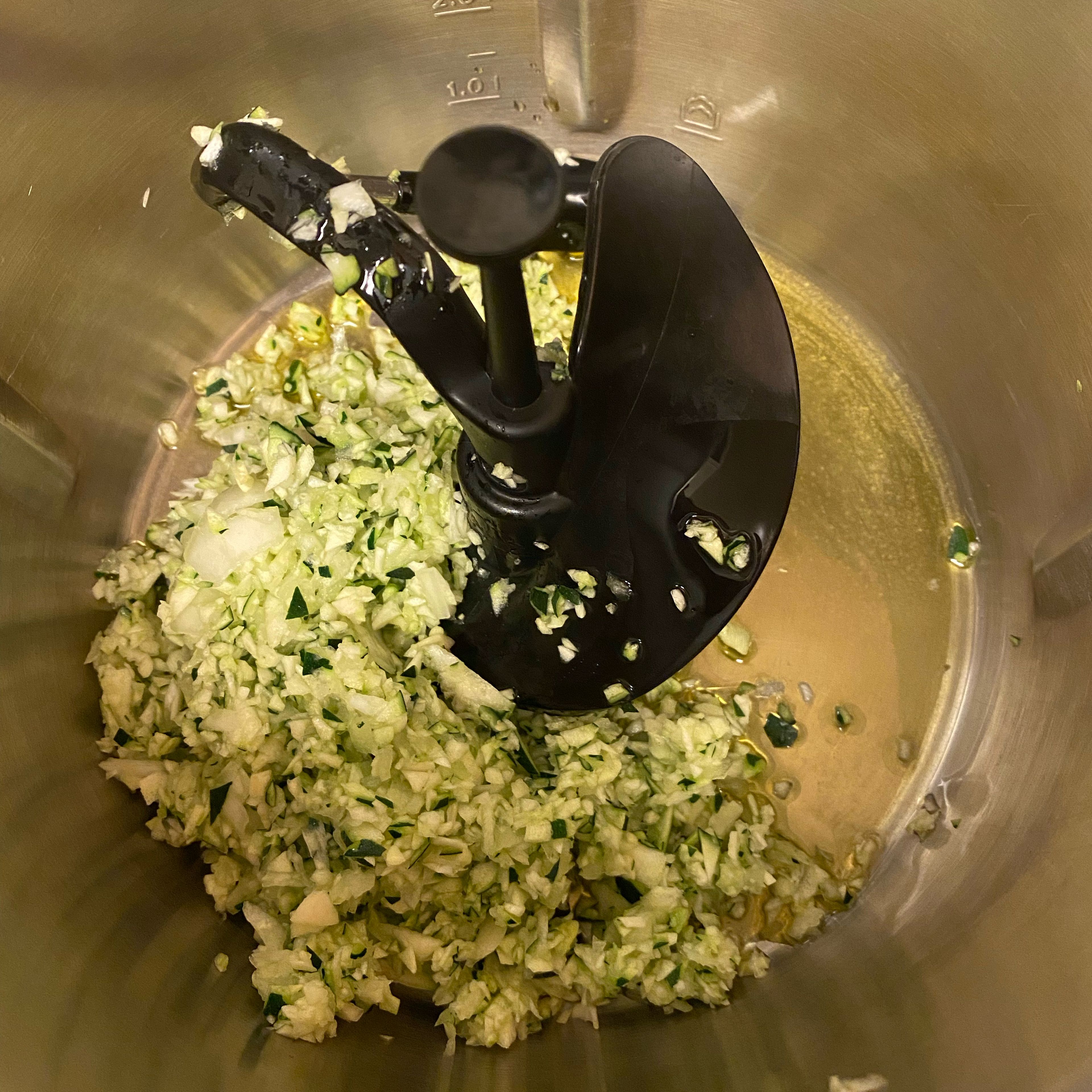 Cookit 3D-Rührer einsetzen, Olivenöl, Zwiebeln, Zucchini und Knoblauch zugeben und anschwitzen. (Cookit 3D-Rührer I 140Grad I 4Min)