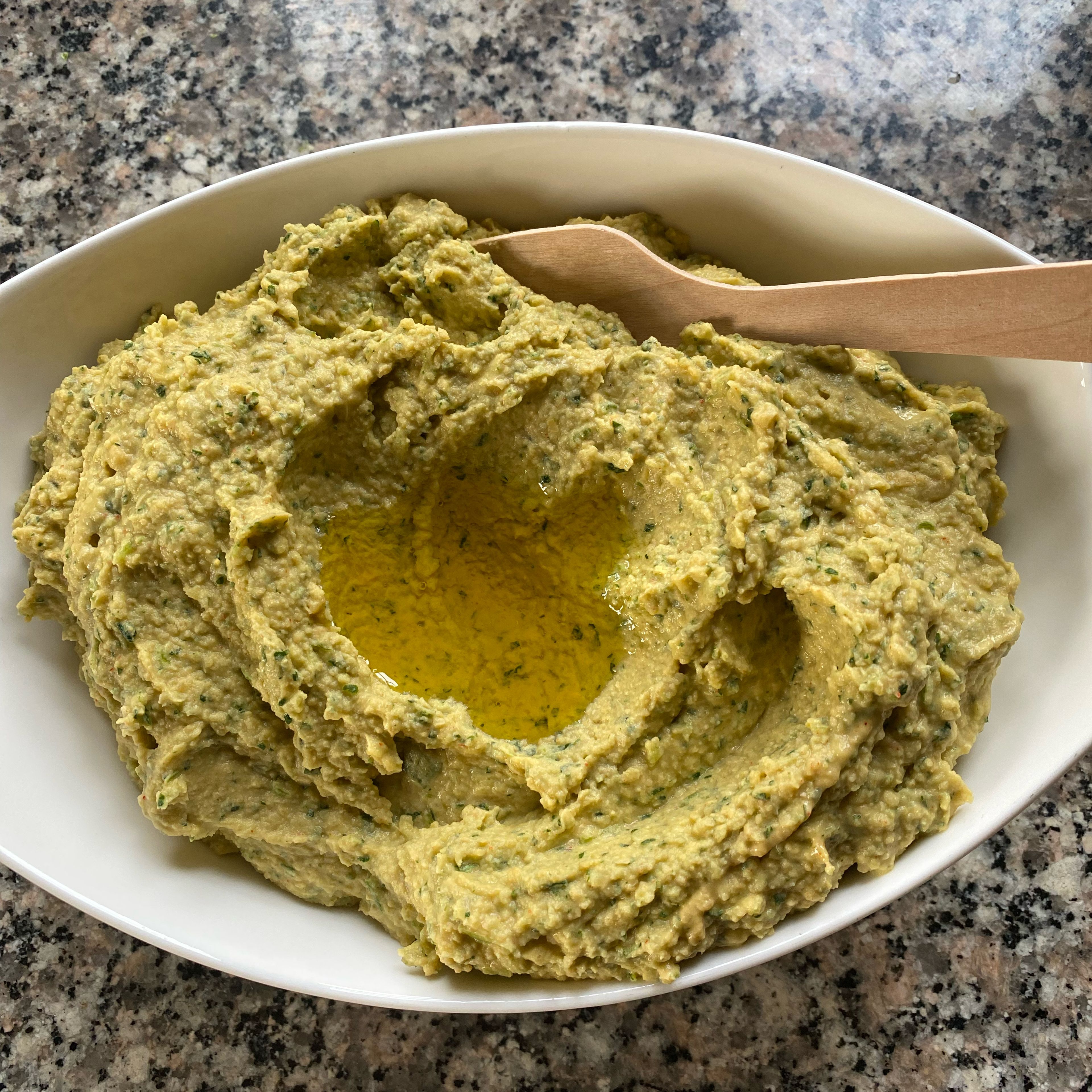 Cookit Universalmesser entnehmen, Petersilien-Hummus mit dem Cookit Küchenspatel in eine Schüssel umfüllen, mit Olivenöl garnieren.