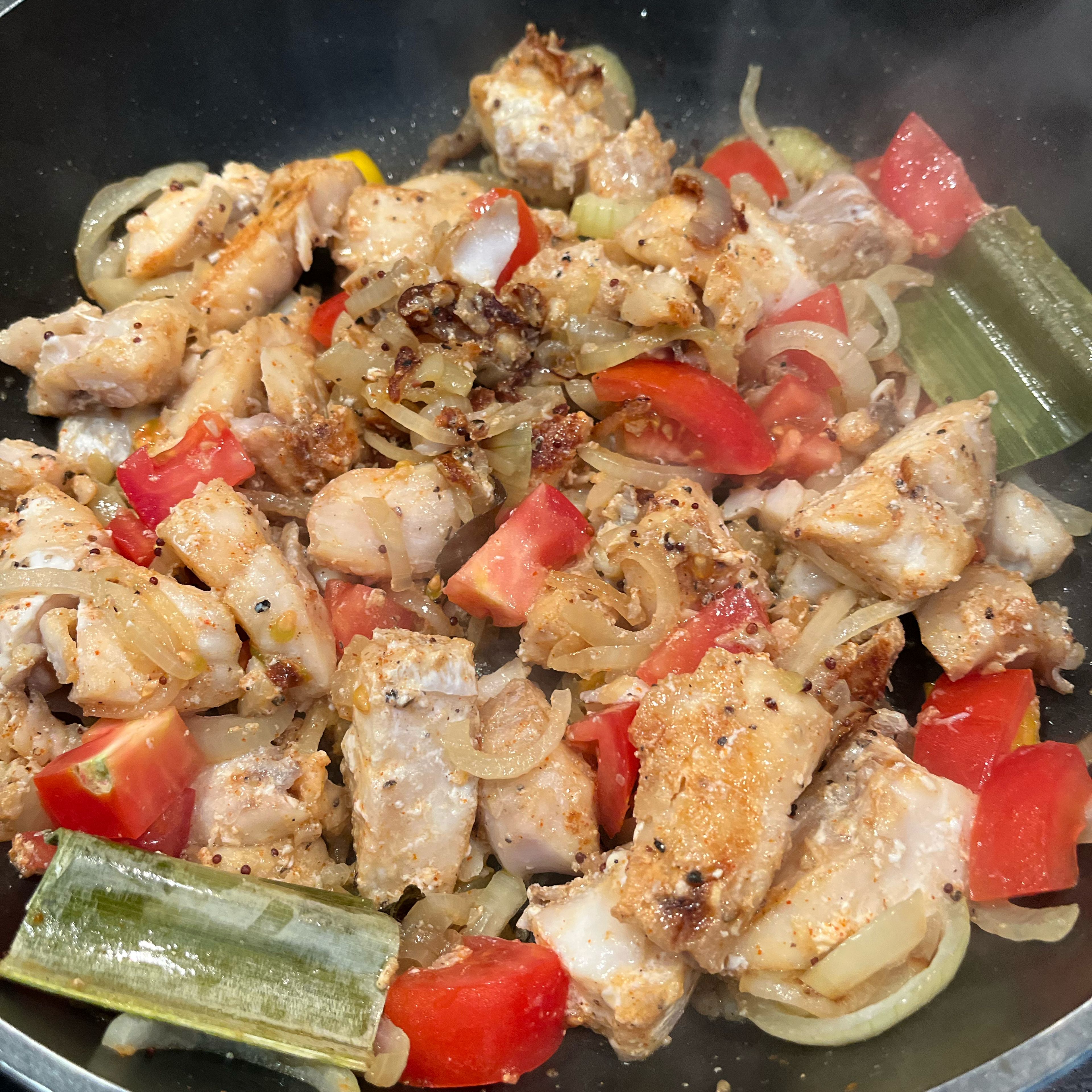 When bottom of the fish starts to brown, turn fish and mix with onions, add tomatoes at the end. Sauté for another 2min and remove from heat. Serve with rice, parippu and a vegetable dish, e.g. swiss chard.