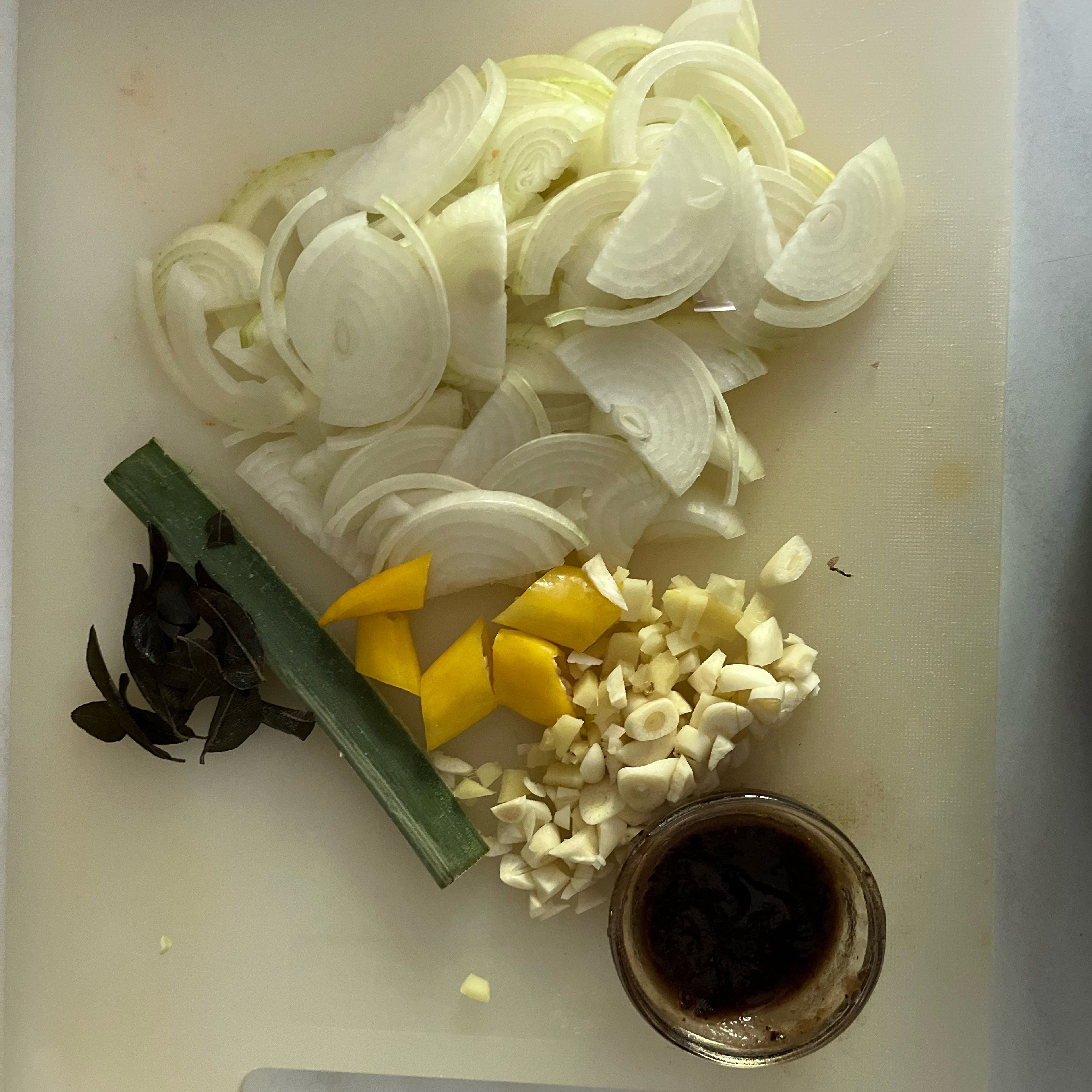 Slice onions, chop garlic, ginger and chili. Peel and soak tamarind pulp in a table spoon of water. Remove curry leaves from sprig and cut a piece of pandan leave.