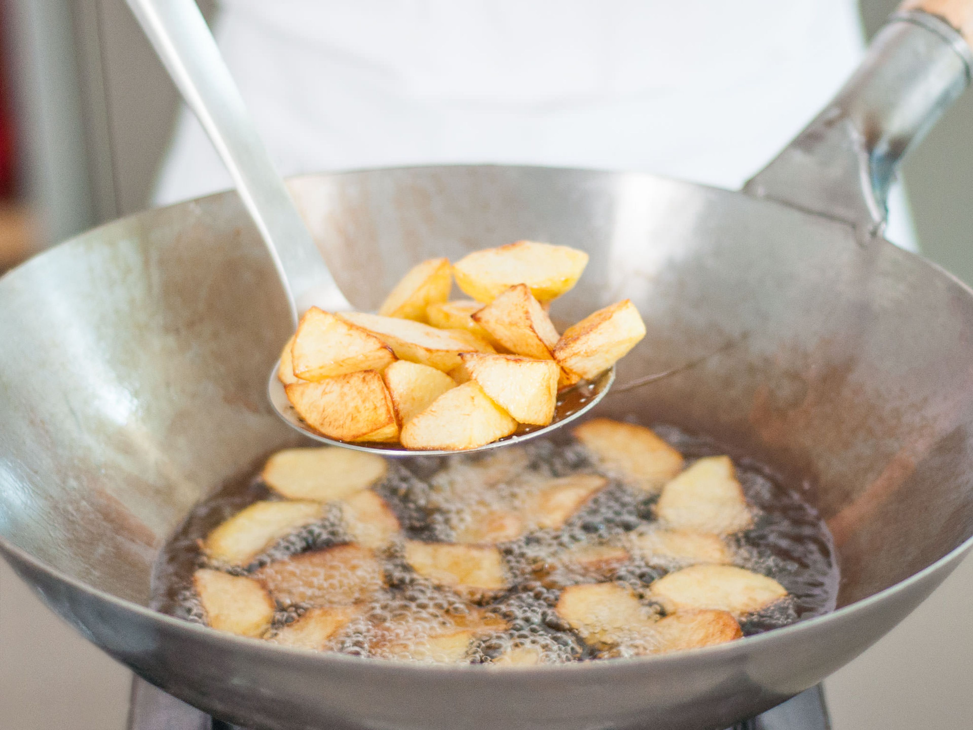 Deep fry potatoes until golden brown, remove with a slotted spoon, and transfer to a paper towel-lined plate to drain.