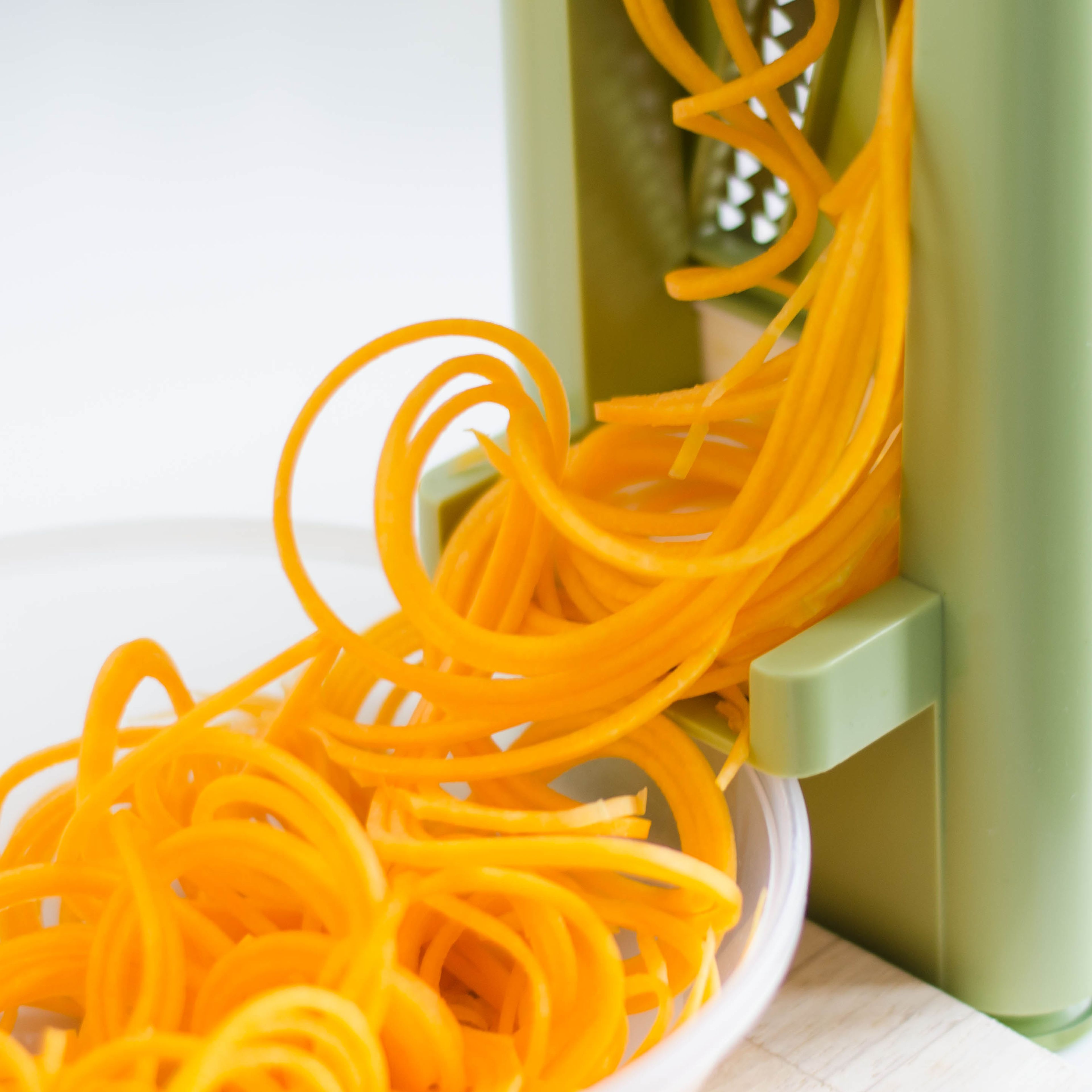 Cut off the head of the butternut squash and peel. Cut squash into spaghetti using a vegetable spiralizer. Add quinoa to a sieve and rinse under cold water. Then transfer to a pot with water, bring to a boil, and cook for approx. 15 min. Meanwhile wash leek and finely cut into rings. Mince garlic and slice chili. Set aside.