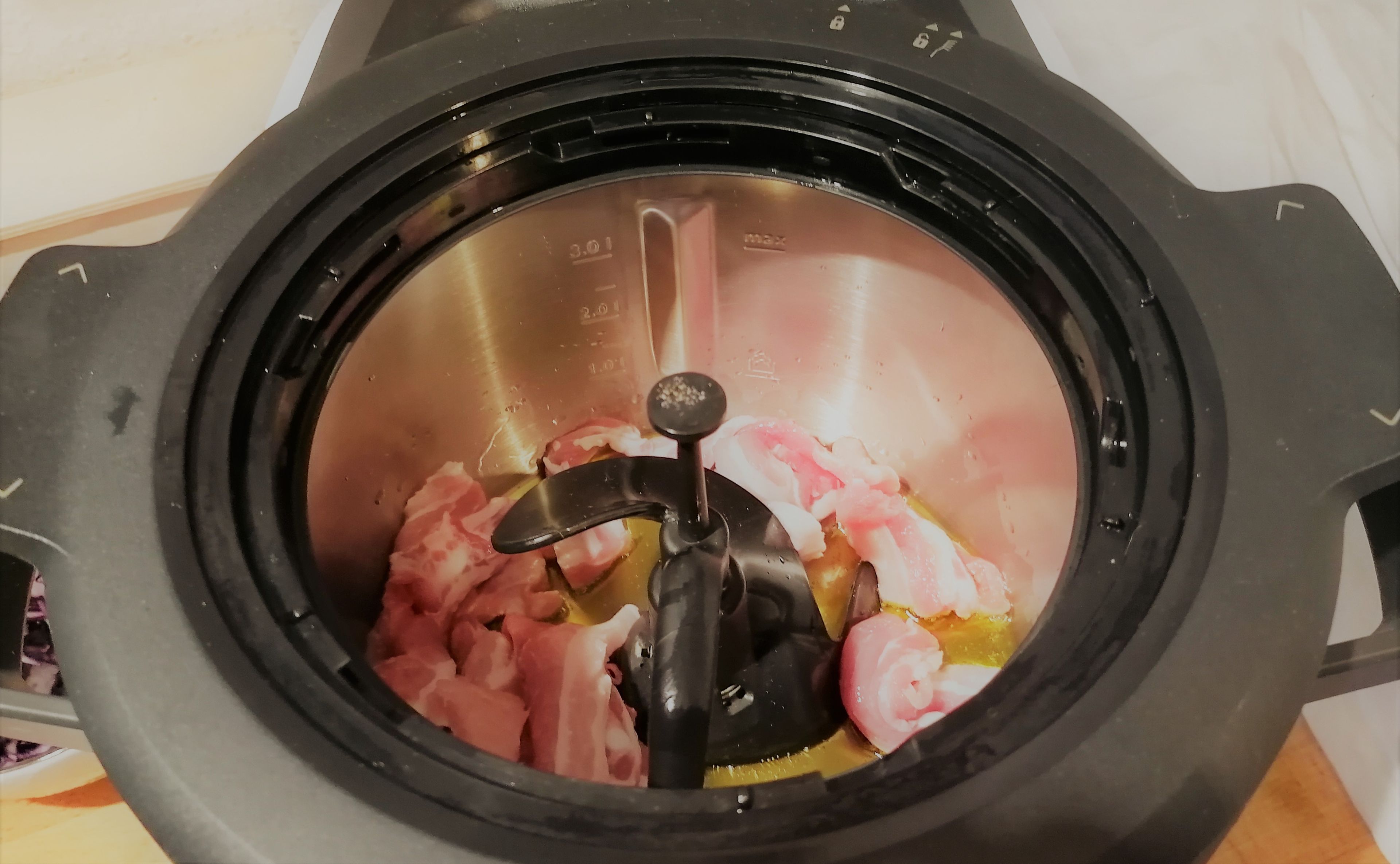 Für den Schweinebauch das Fleisch in ca. 5 cm lange und 0,5 cm breite Streifen schneiden. Frühlingszwiebel waschen und in Ringe schneiden, Knoblauch und Ingwer schälen und fein hacken. 
3D-Rührer einsetzen, Sesamöl in den Topf geben, den Deckel schließen und das Öl, ohne den Messbecher einzusetzen, erhitzen (3D-Rührer | Stufe 0 | 200°C | 4 Minuten).