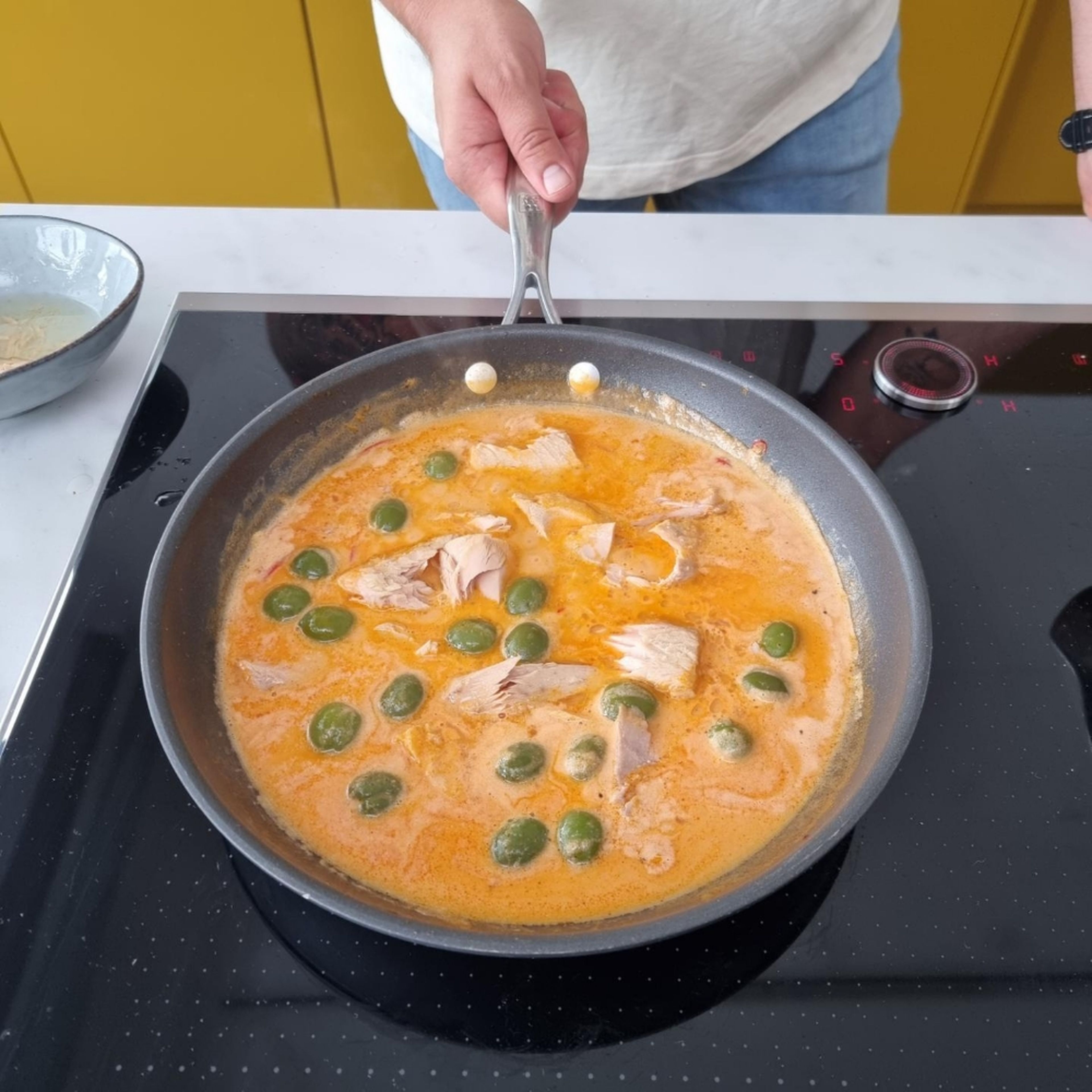 Nudeln abgießen. Mit der Thunfisch–Soße mischen und anrichten. Mit Parmesan bestreuen und mit Petersilie garnieren.