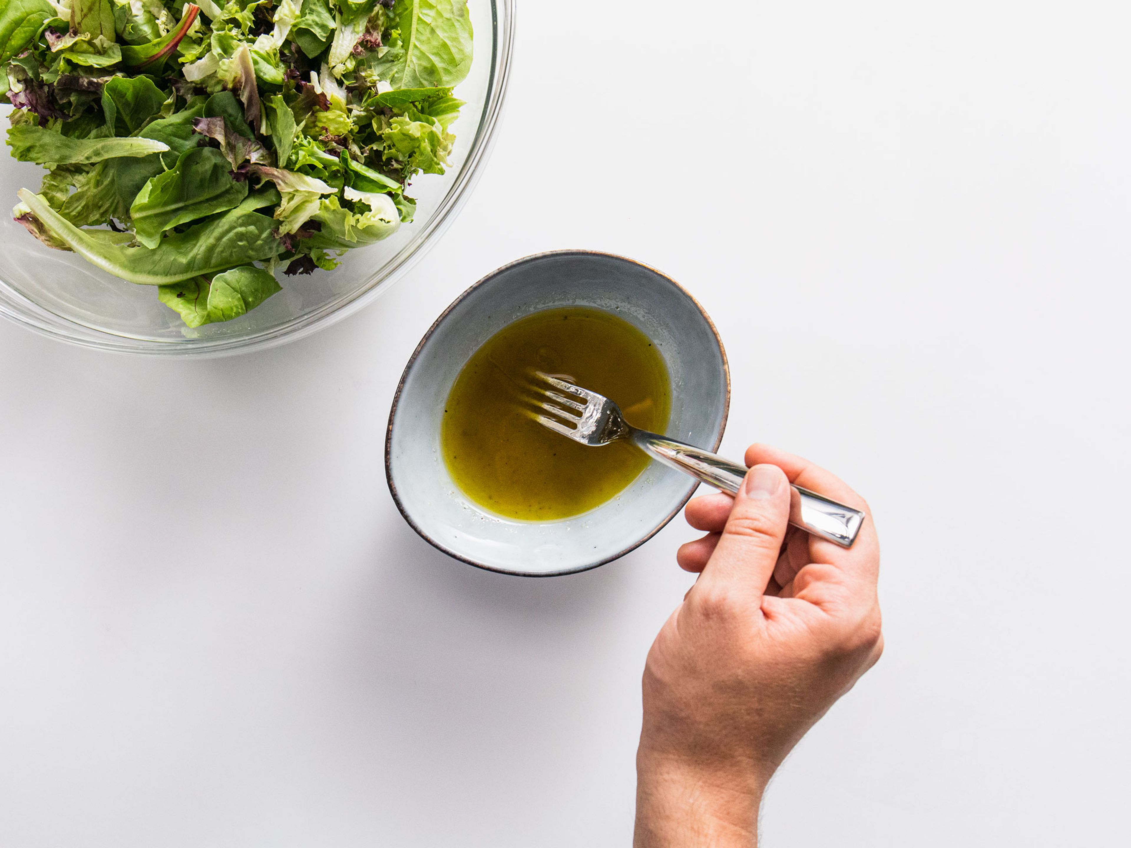 Für das Salatdressing den restlichen Zitronensaft mit Olivenöl, Salz, Pfeffer und Zucker verrühren. Bis zum Servieren beiseitestellen.