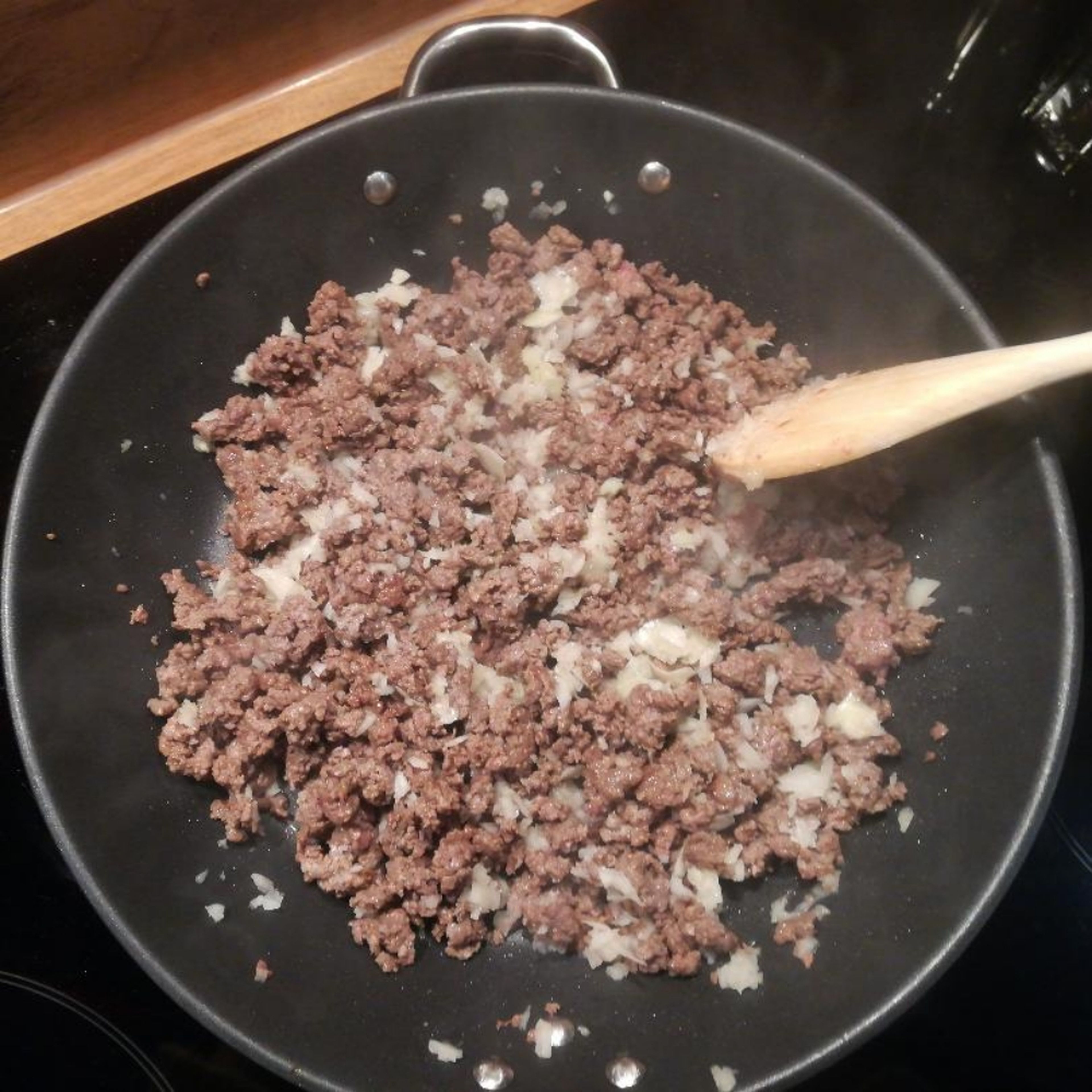 Zwiebel & Knoblauch in feine Würfel schneiden und zum Hackfleisch geben (ca. 3min mit anbraten).