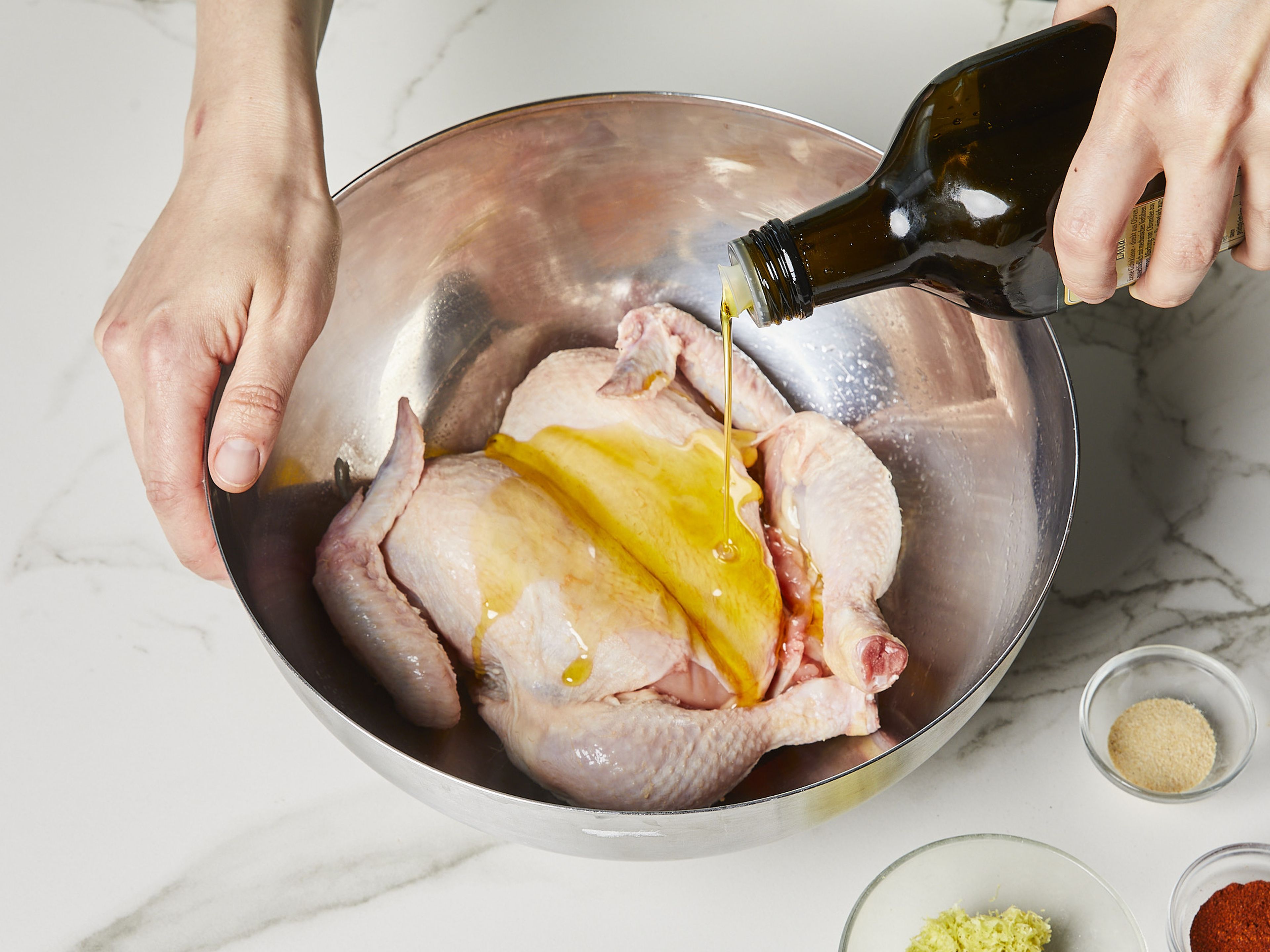 Das Hähnchen nach unserer Videoanleitung "Plattes Huhn zum Braten" vorbereiten und mit Papiertüchern trocken tupfen. Zitronenschale abreiben und Zitrone in Spalten schneiden. Für die Marinade Paprikapulver mit Zitronenabrieb, Olivenöl, Salz und Knoblauchpulver in einer kleinen Schüssel vermischen. Das vorbereitete Hähnchen damit einreiben und ca. 15–30 Min. marinieren lassen. Den Grill oder die Grillpfanne im Backofen auf ca. 220°C vorheizen.