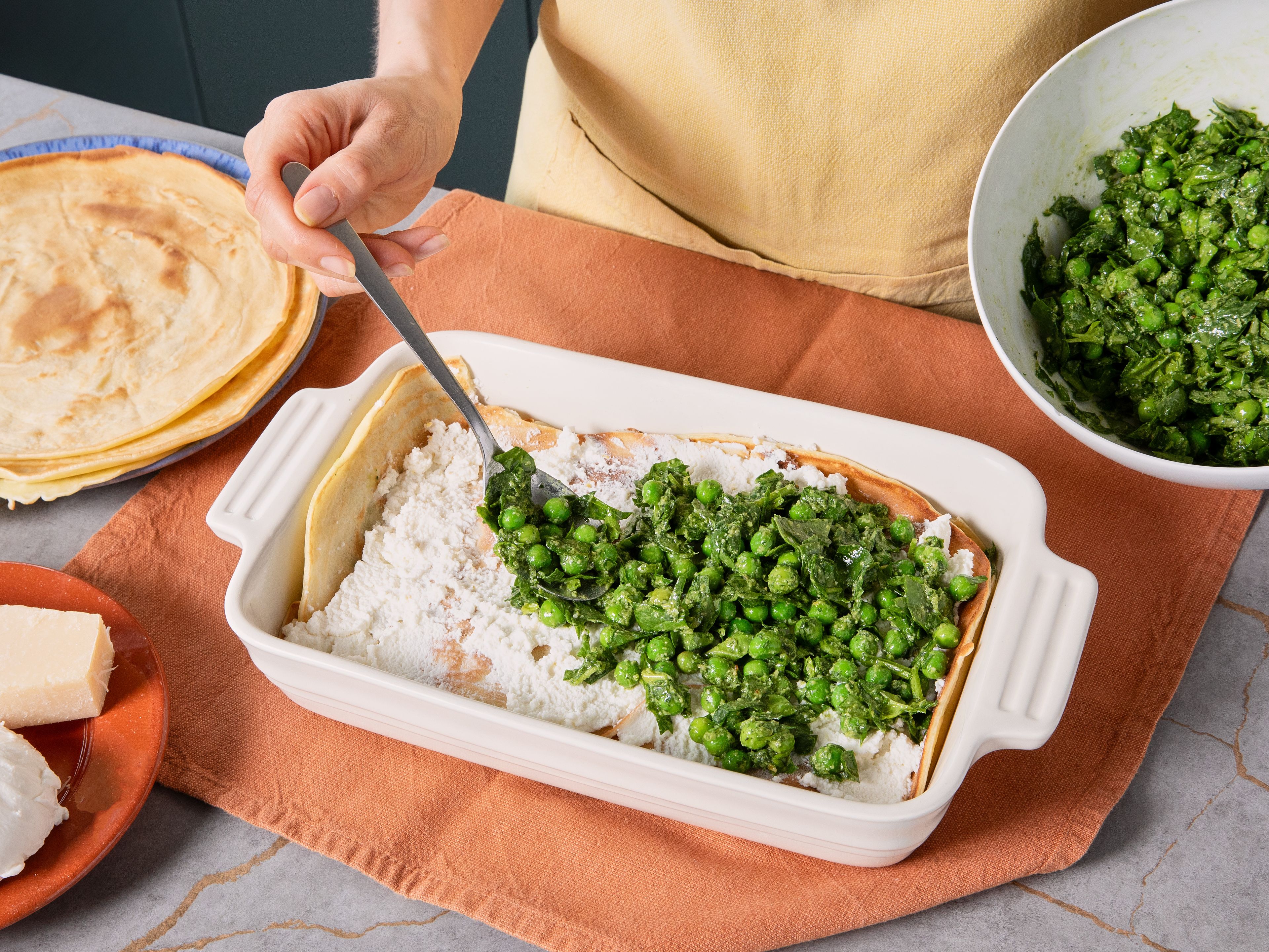 Preheat the oven to 230 °C/450 °F (top/bottom heat or grill function). In a baking dish, layer crêpes, ricotta, and pesto mix (approx. 3 layers each). Finish with mozzarella and the remaining parmesan. Bake the lasagna in the oven for approx. 10 min., until the cheese is golden and crispy. Serve while hot.