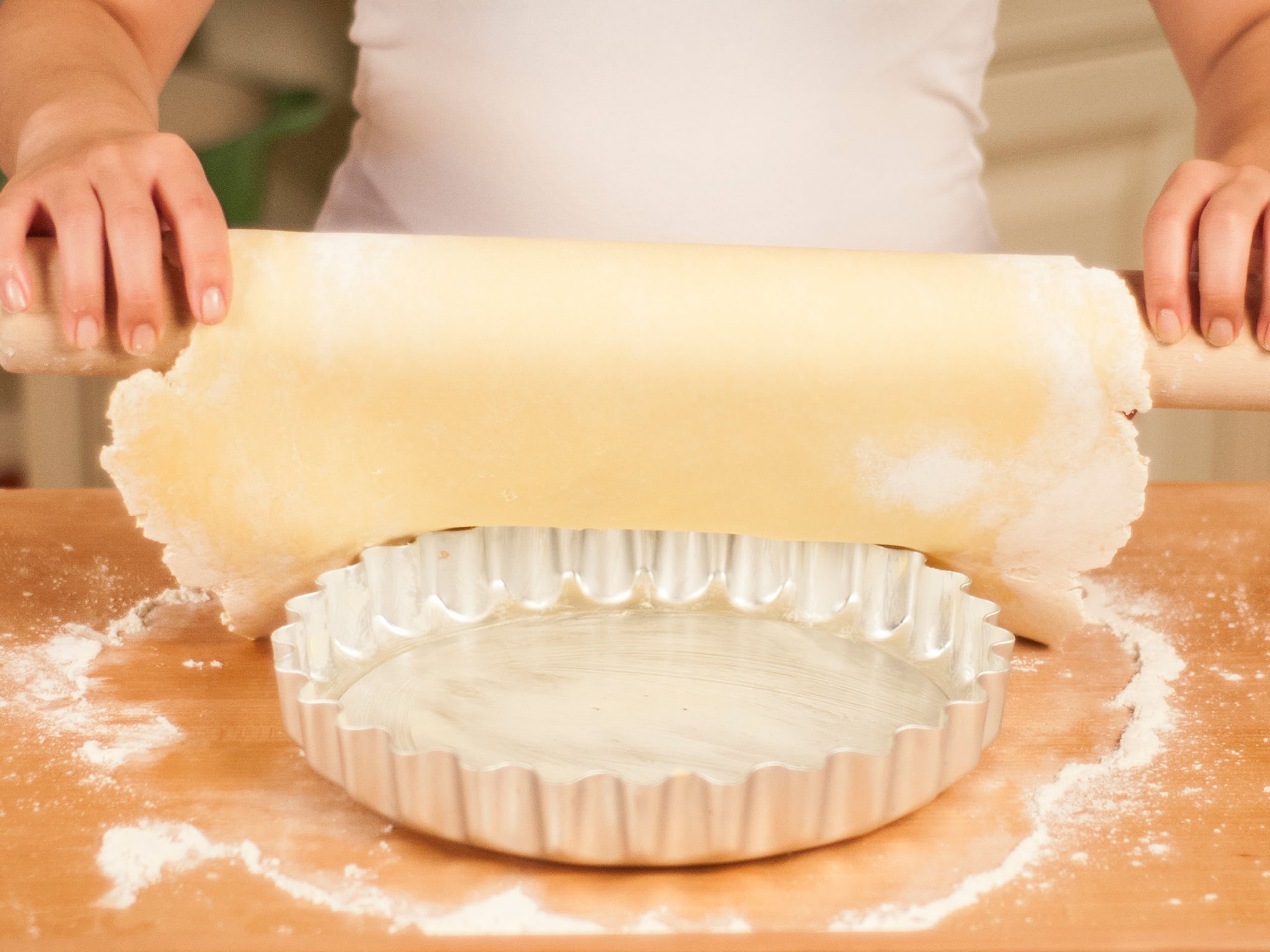 Lay the dough into the tart dish, leaving an edge. Press the sides firmly into the dish.
