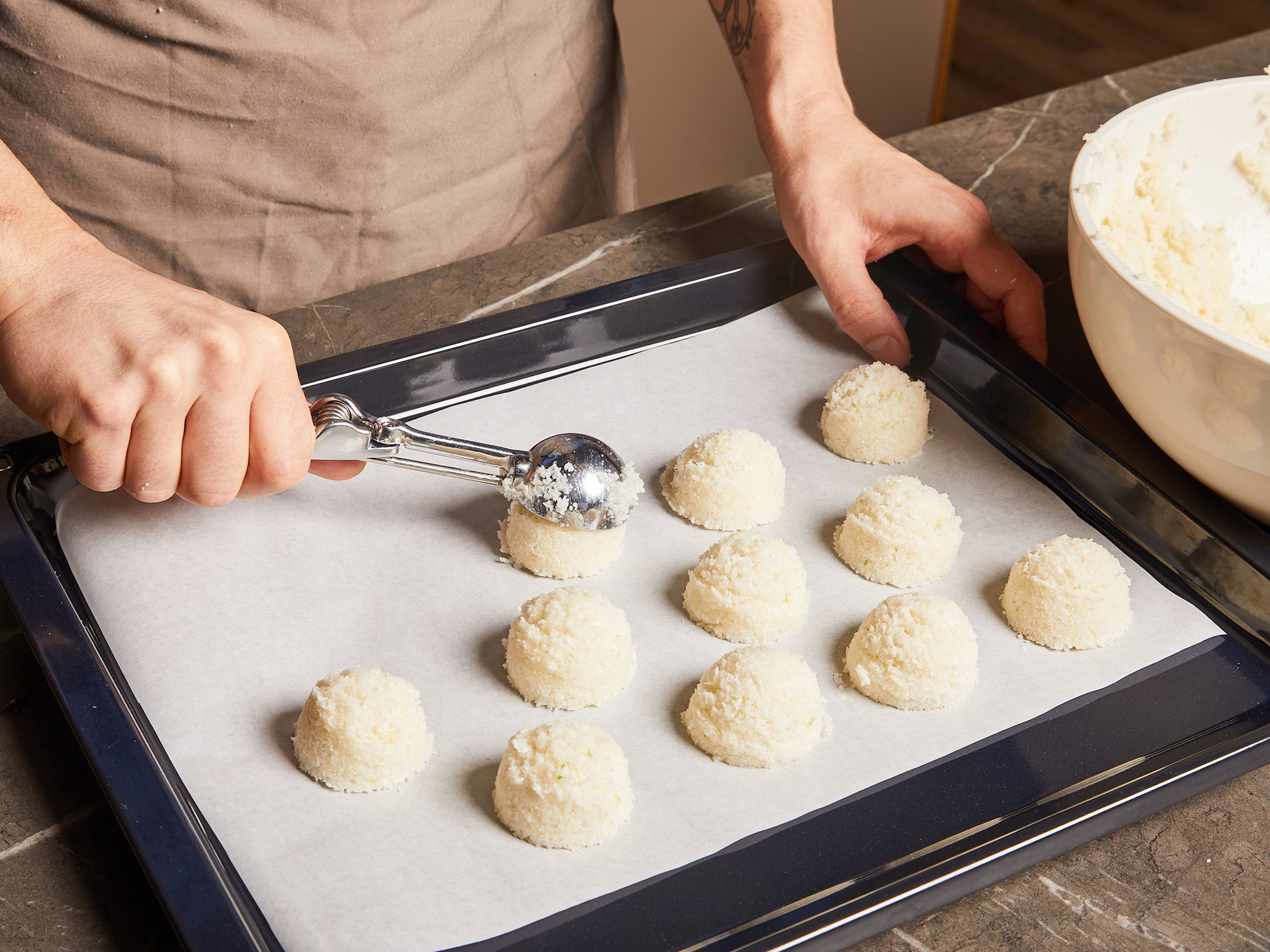 Preheat the oven to 165°C/330°F convection heat (or 185°C/365°F top-bottom heat). Line a baking sheet with parchment paper. Use an ice cream scoop or spoon to lightly shape the coconut mixture into 20 small cones and place on the baking tray. Transfer to the oven and bake on the middle rack for approx. 10–15 min. The macaroons should be lightly browned but still a little soft. Remove from the oven and leave to cool completely. Only then carefully remove from the parchment paper.