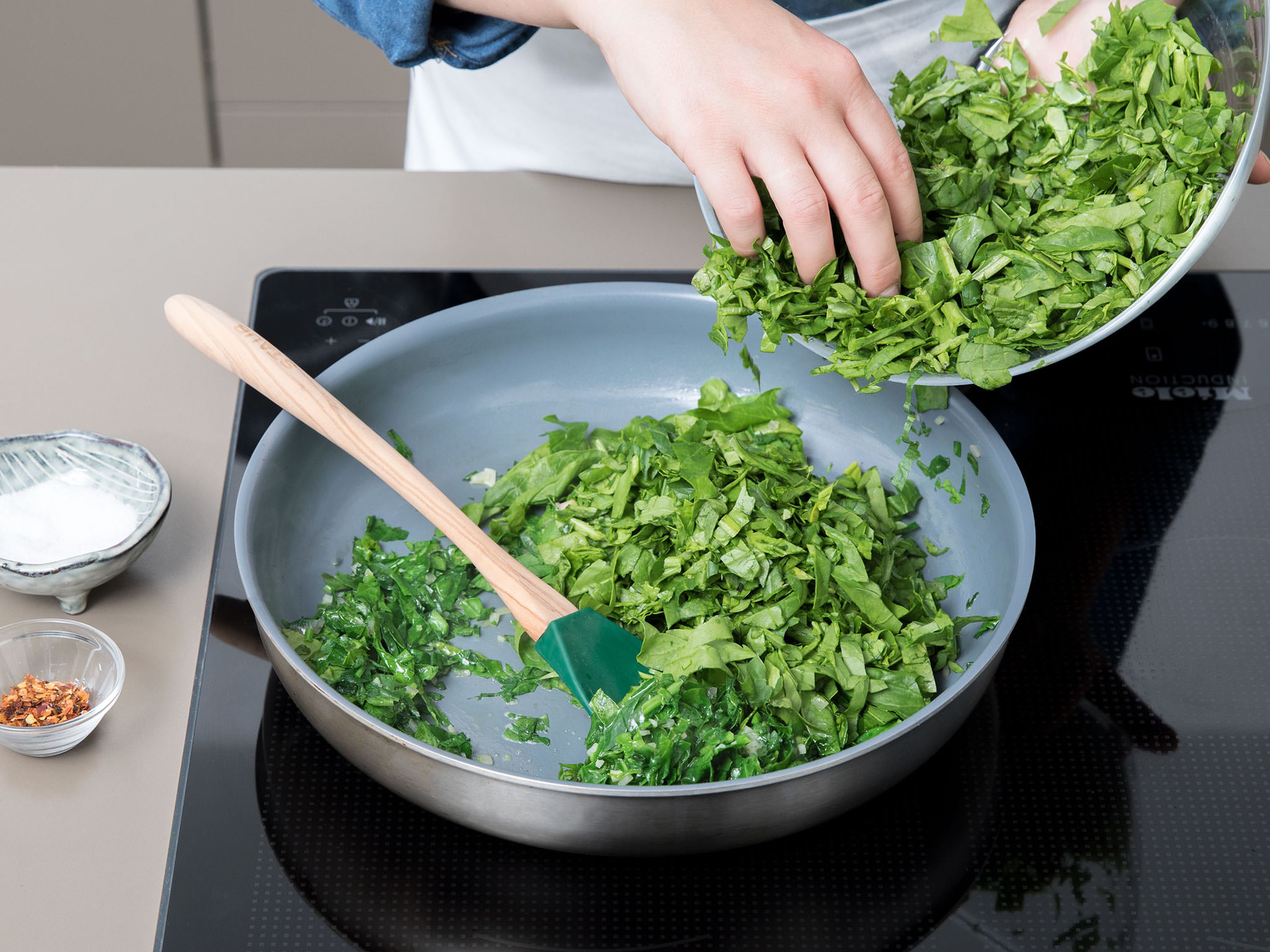 Add the chopped spinach to the frying pan. Sprinkle with chili flakes. Sauté for approx. 3 min., stirring frequently. Once all the liquid has evaporated, add the artichokes, and season with salt and pepper. Let cook for approx. 2 min. more.