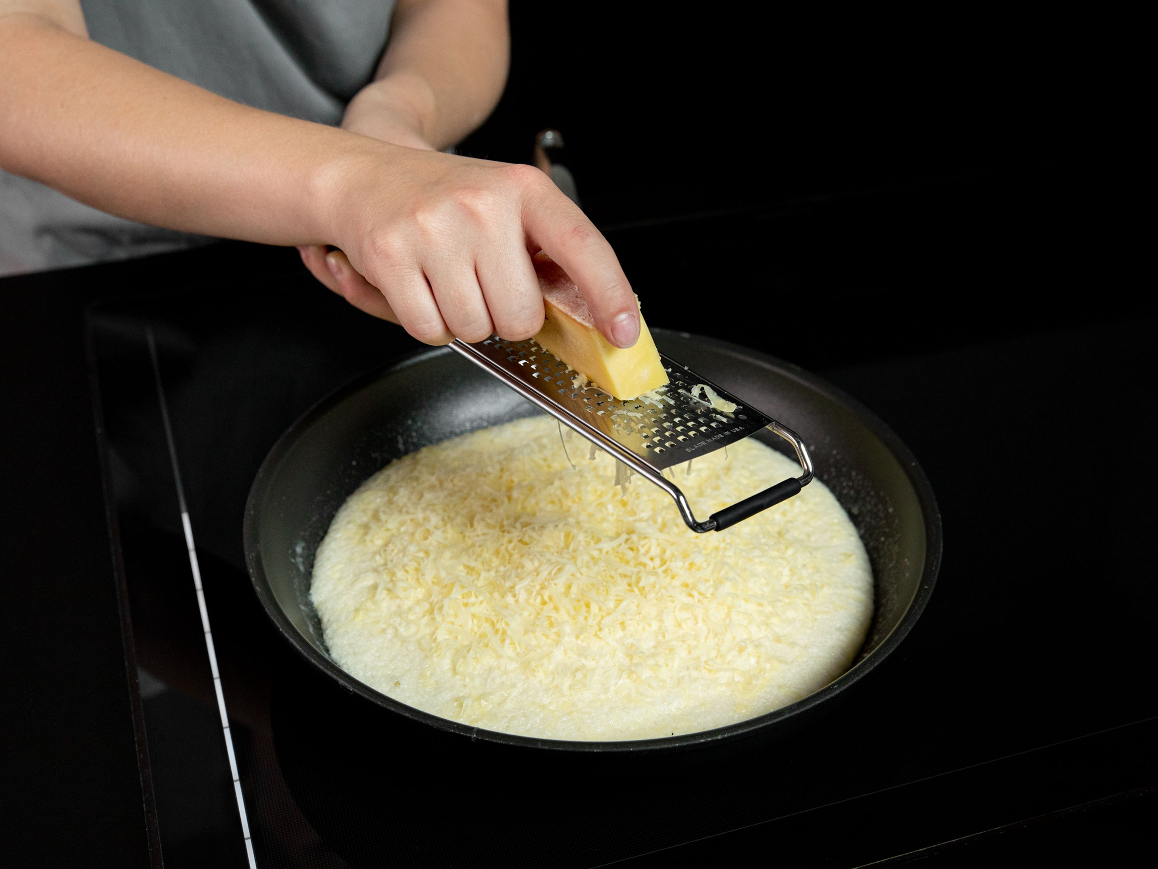Butter in  eine beschichtete Pfanne über mittlerer Hitze geben. Sobald die Butter geschmolzen ist, in der Pfanne schwenken. Eimischung dazugeben, glatt streichen und die Hälfte des Käses darüber reiben. Einen Deckel auf die Pfanne setzen und das Omelette ca. 3 Min. garen.