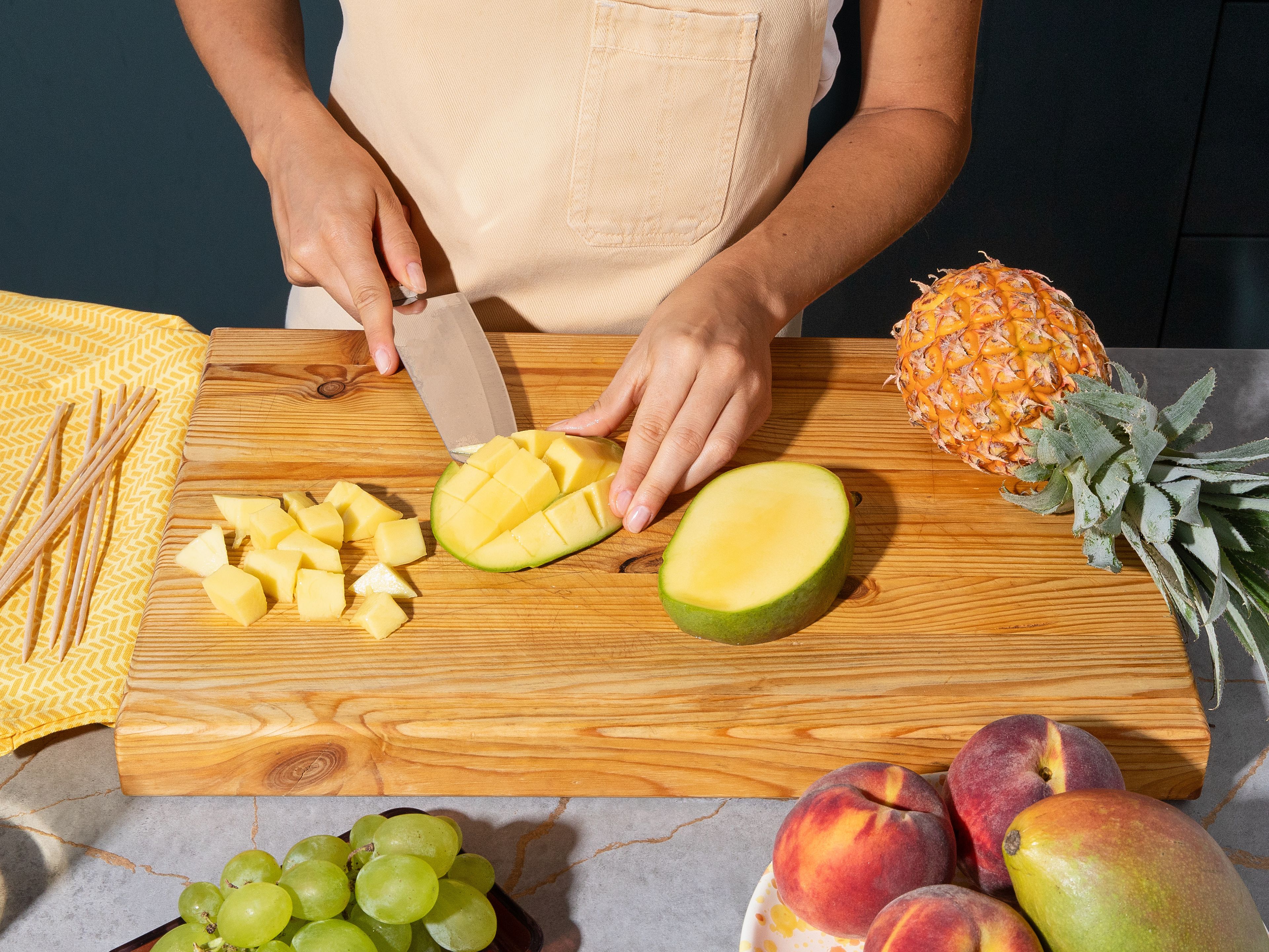 Ananas, Mango und Pfirsiche in mundgerechte Stücke schneiden und zusammen mit den Trauben auf Spieße ziehen. Dabei oben und unten jeweils etwas Platz für die Solero Bonbons lassen. Die Fruchtspieße gründlich trocken tupfen und bis zur Verwendung in den Tiefkühler legen.