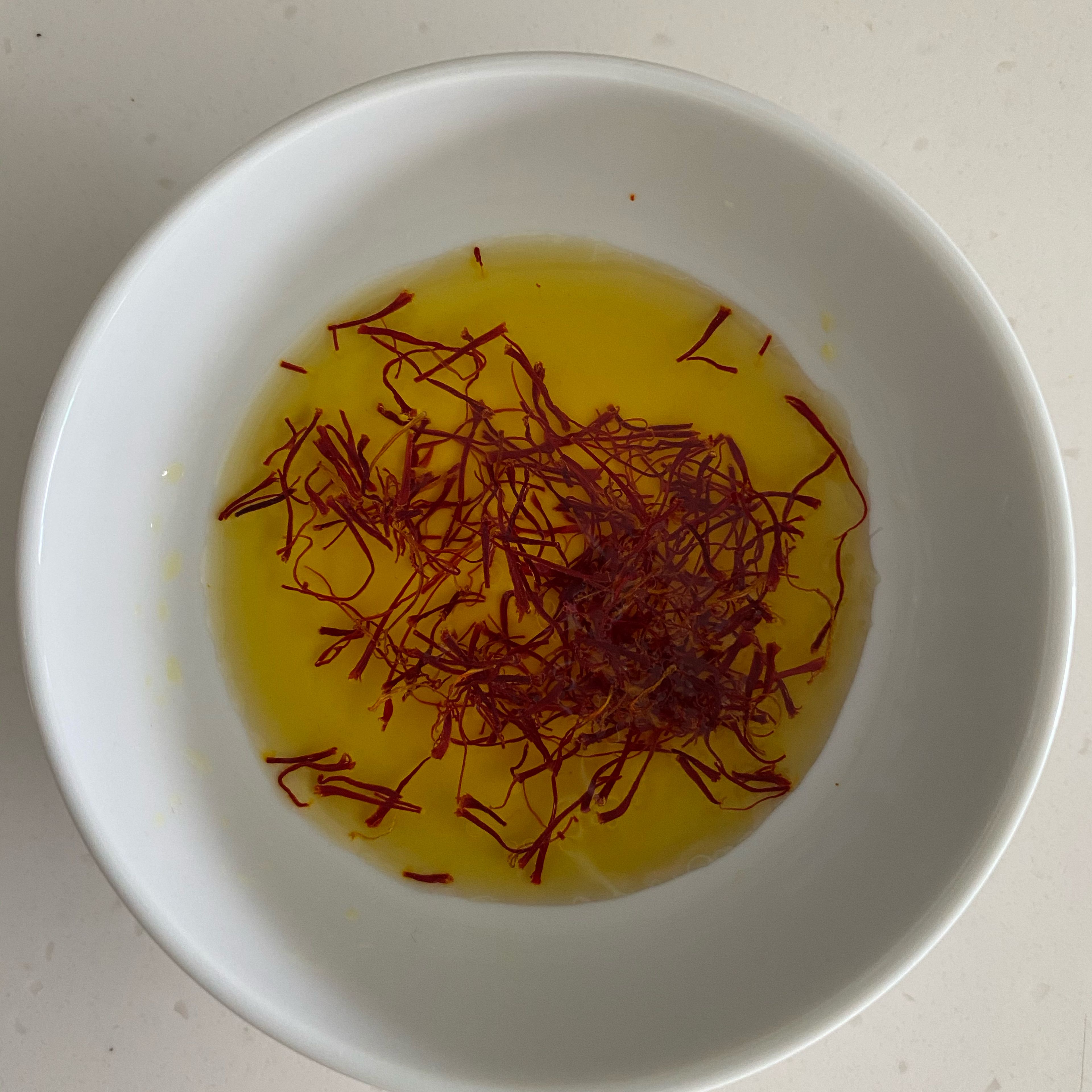 To make the saffron risotto, first put the pistils of saffron in a small bowl, pour enough water (2-3 tablespoons) over them to completely cover the pistils, stir and leave to infuse a couple of hours, in this way the pistils will release all their colour.
