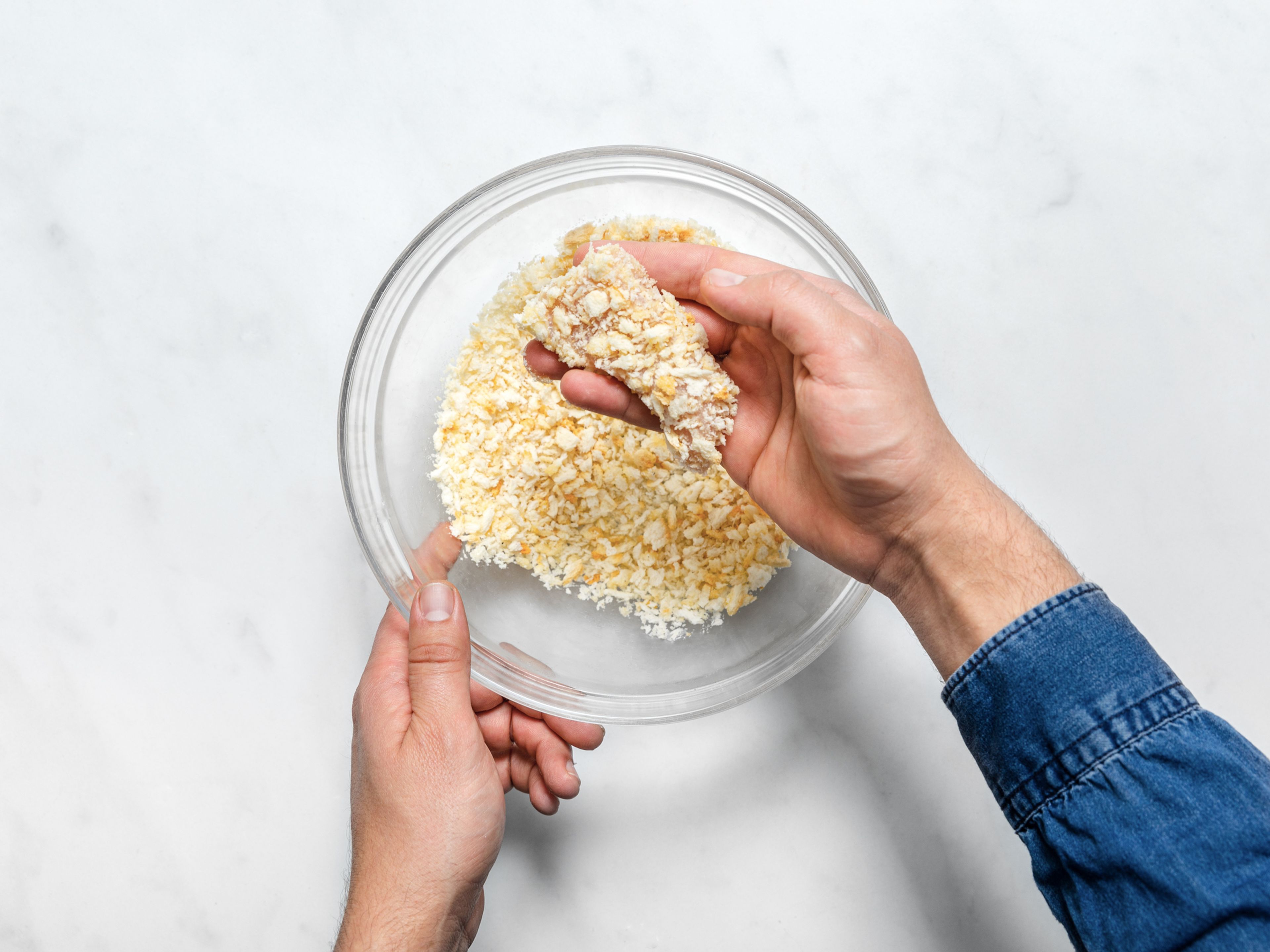 Transfer cooled, toasted breadcrumbs to another large bowl. Dredge the chicken strips completely in breadcrumbs, then transfer to the same baking sheet you toasted the breadcrumbs on. Repeat with all chicken strips.