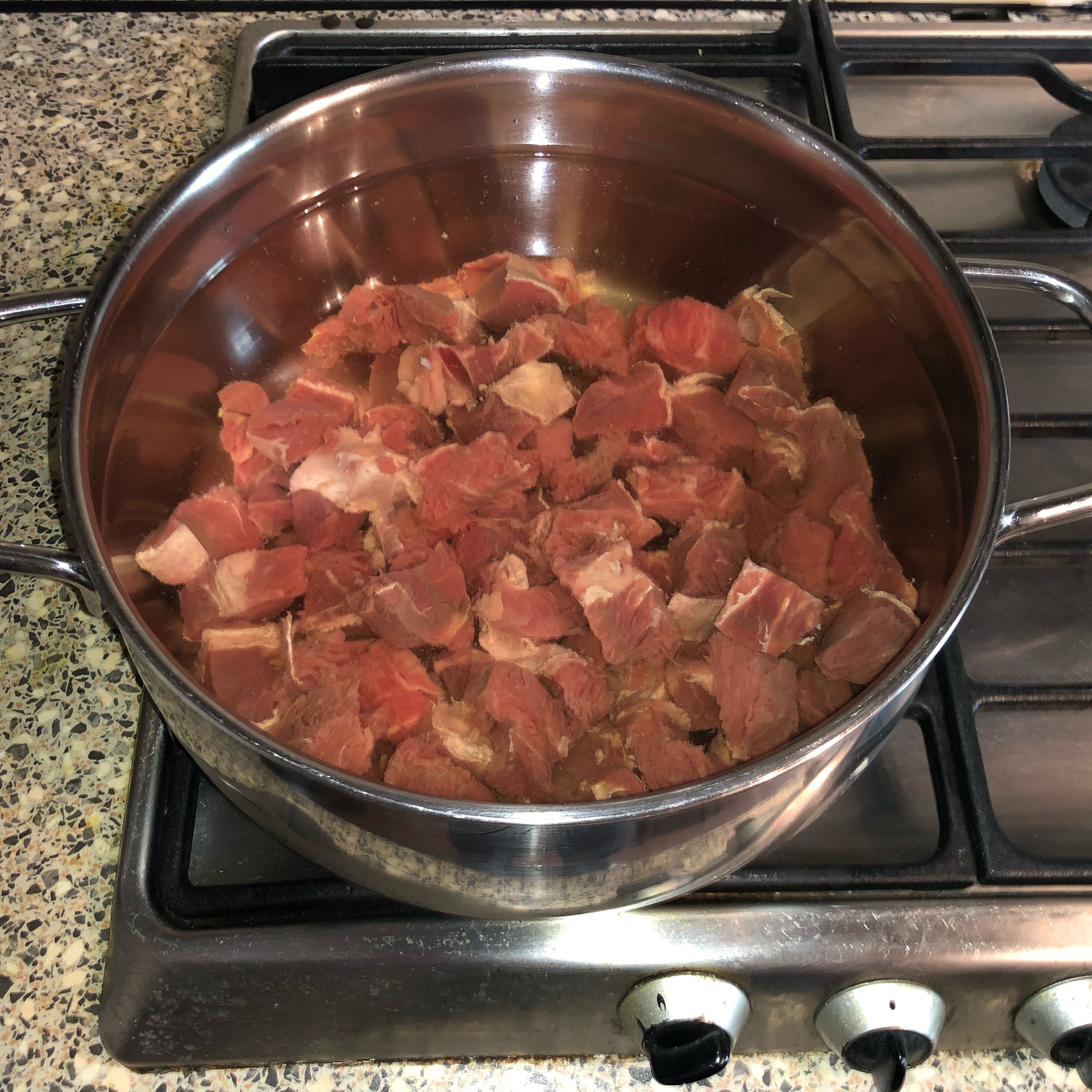 Cut the beef into small chunks, wash and combine with water in a large stockpot. Start cooking in a medium heat.