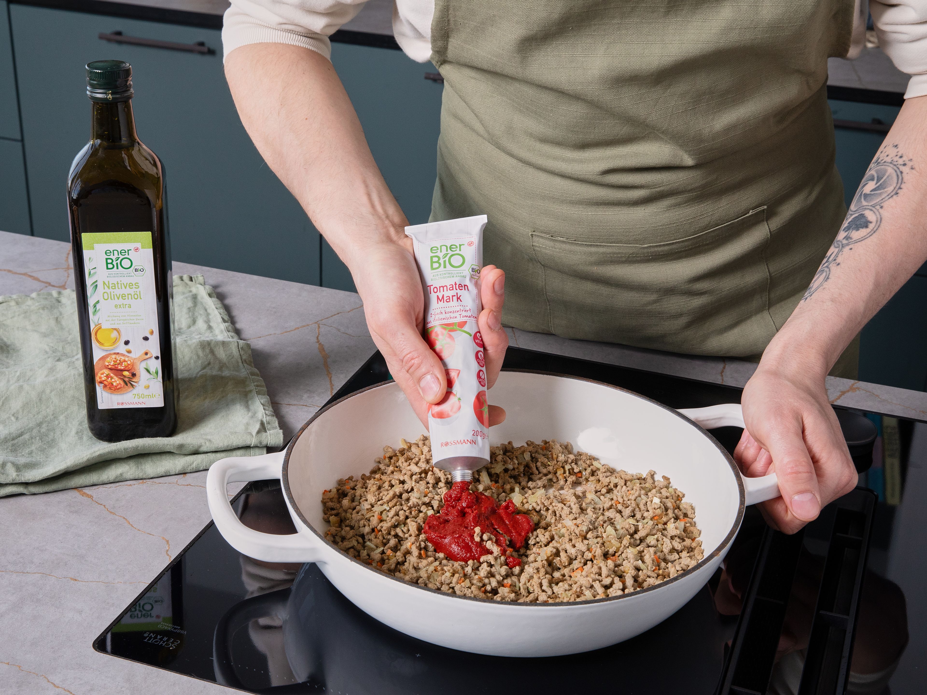 In einer großen Pfanne enerBiO Natives Olivenöl extra erhitzen, Zwiebel und Knoblauch darin glasig anschwitzen, dann das abgetropfte Sonnenblumenhack, die aufgehobene Gemüsebrühe und das enerBiO Tomatenmark hinzufügen und unter Rühren ca. 5 Min. anbraten. Die Kirschtomaten in die Pfanne geben. Danach den Spinat hinzufügen und zusammenfallen lassen.