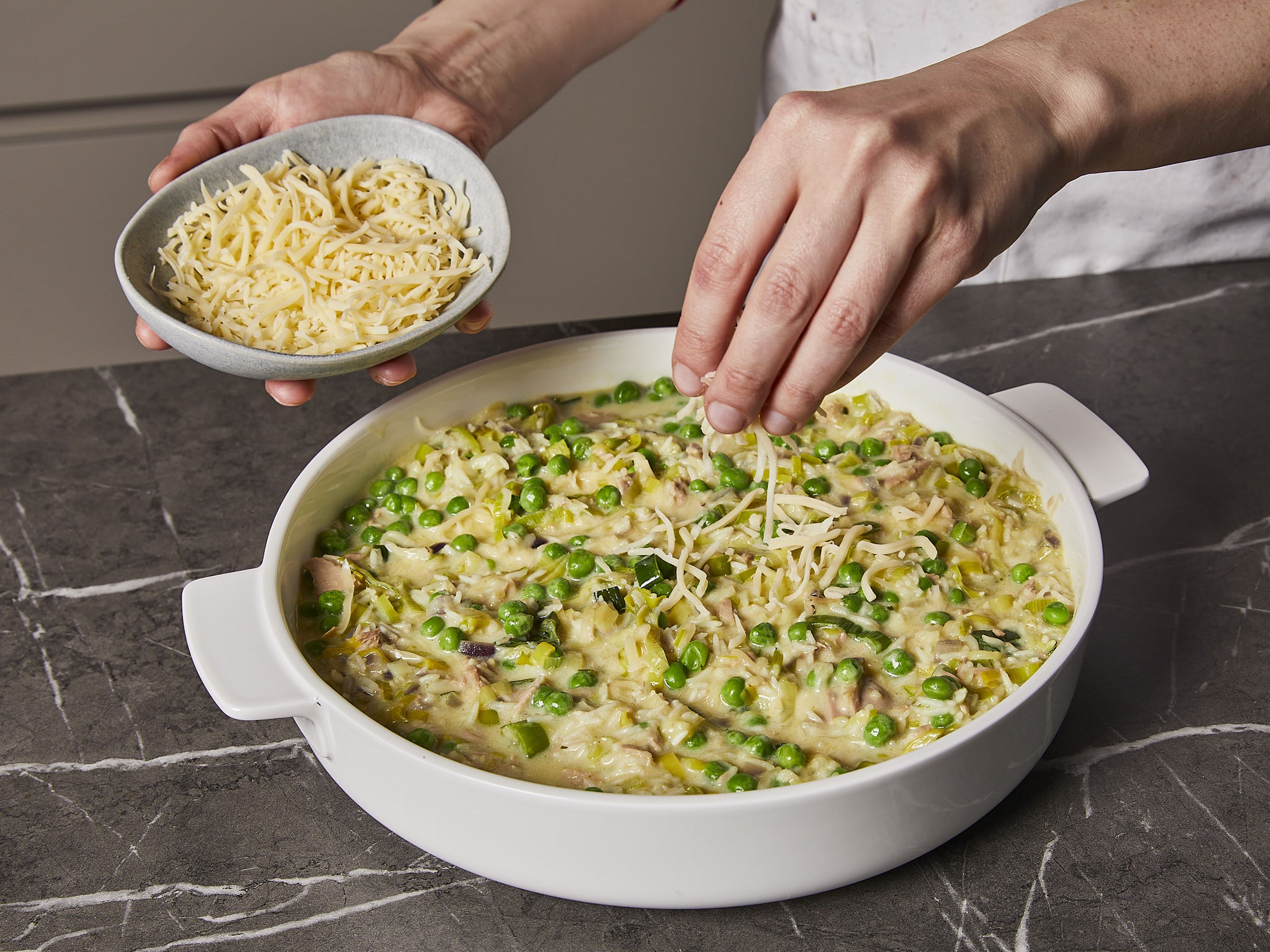 Stir in tuna, frozen peas and ¾ of the cheese. Mix until combined. Then pour everything into a baking dish and sprinkle with the remaining cheese. Bake in the oven for approx. 25 min. until the top turns golden brown. Garnish with remaining scallion greens.