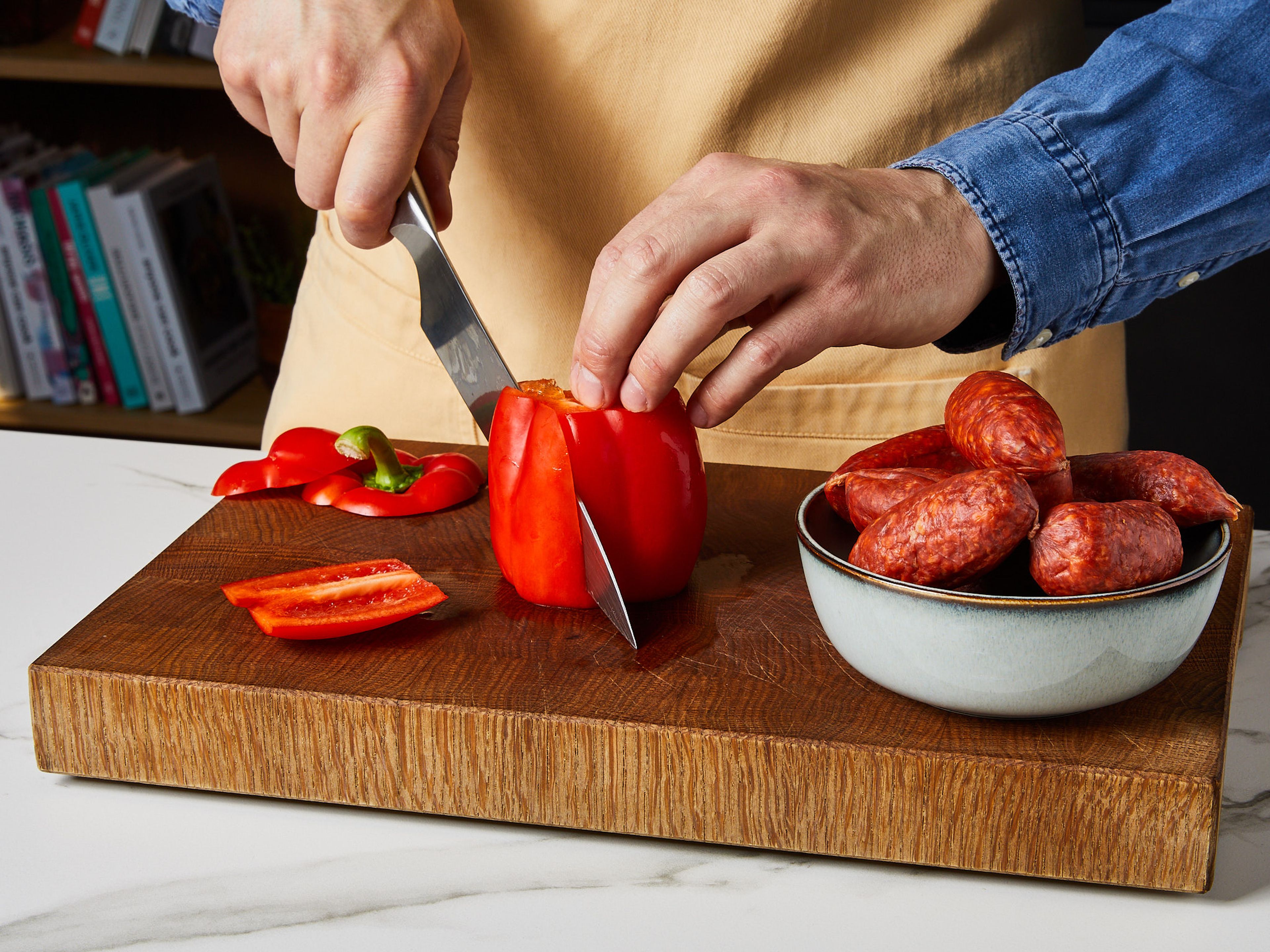 Paprika in vier gleich große Stücke und Chorizo in dicke Scheiben schneiden.