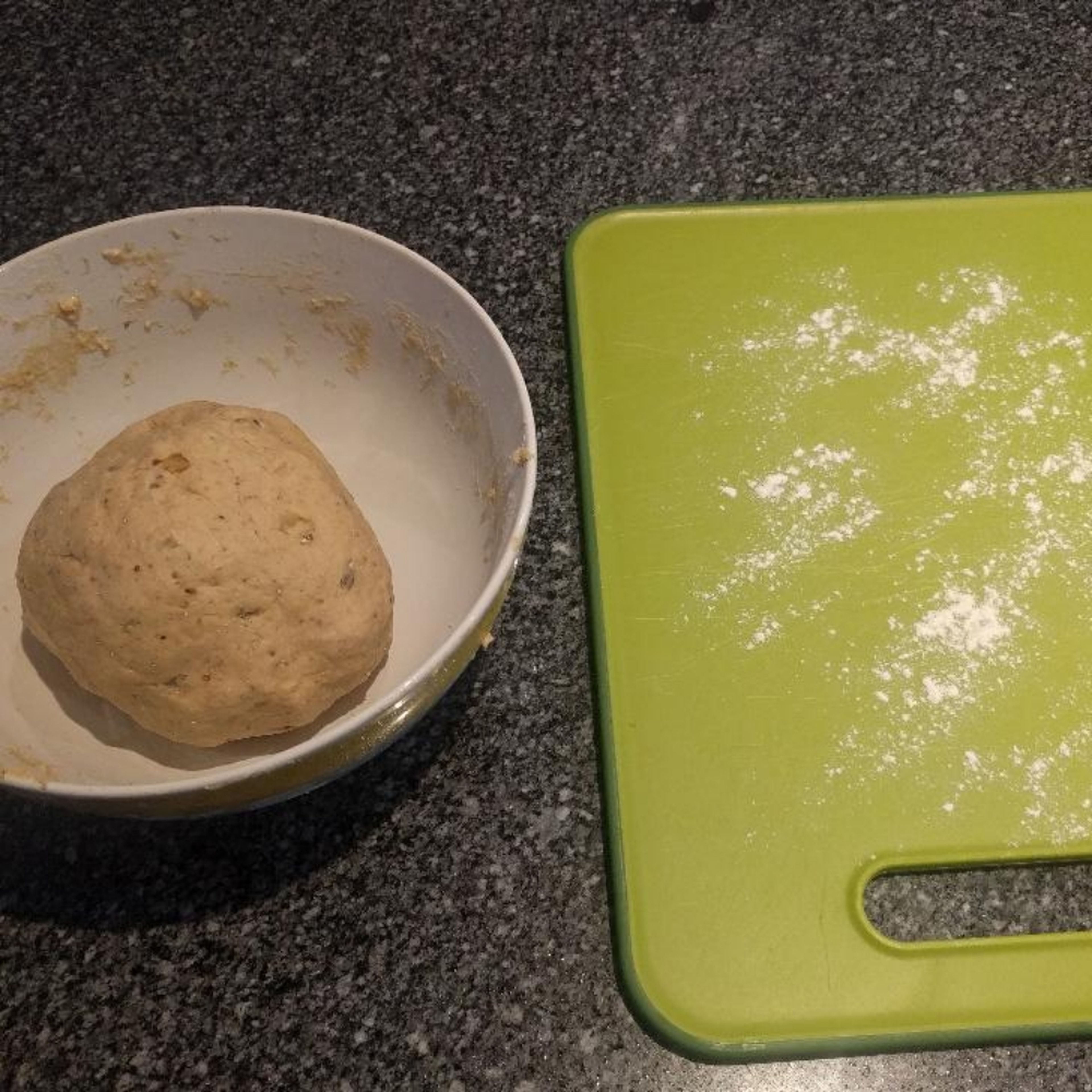 Once you can mould the dough into a small ball, let it rest for about five minutes. Prepare a large cutting board and cover the surface of the board with small amount of white flour. You may not need the flour if you feel the bread isn't sticking. After 5 minutes start molding and stretching the dough into the shape of bread (depending on you baking tray).