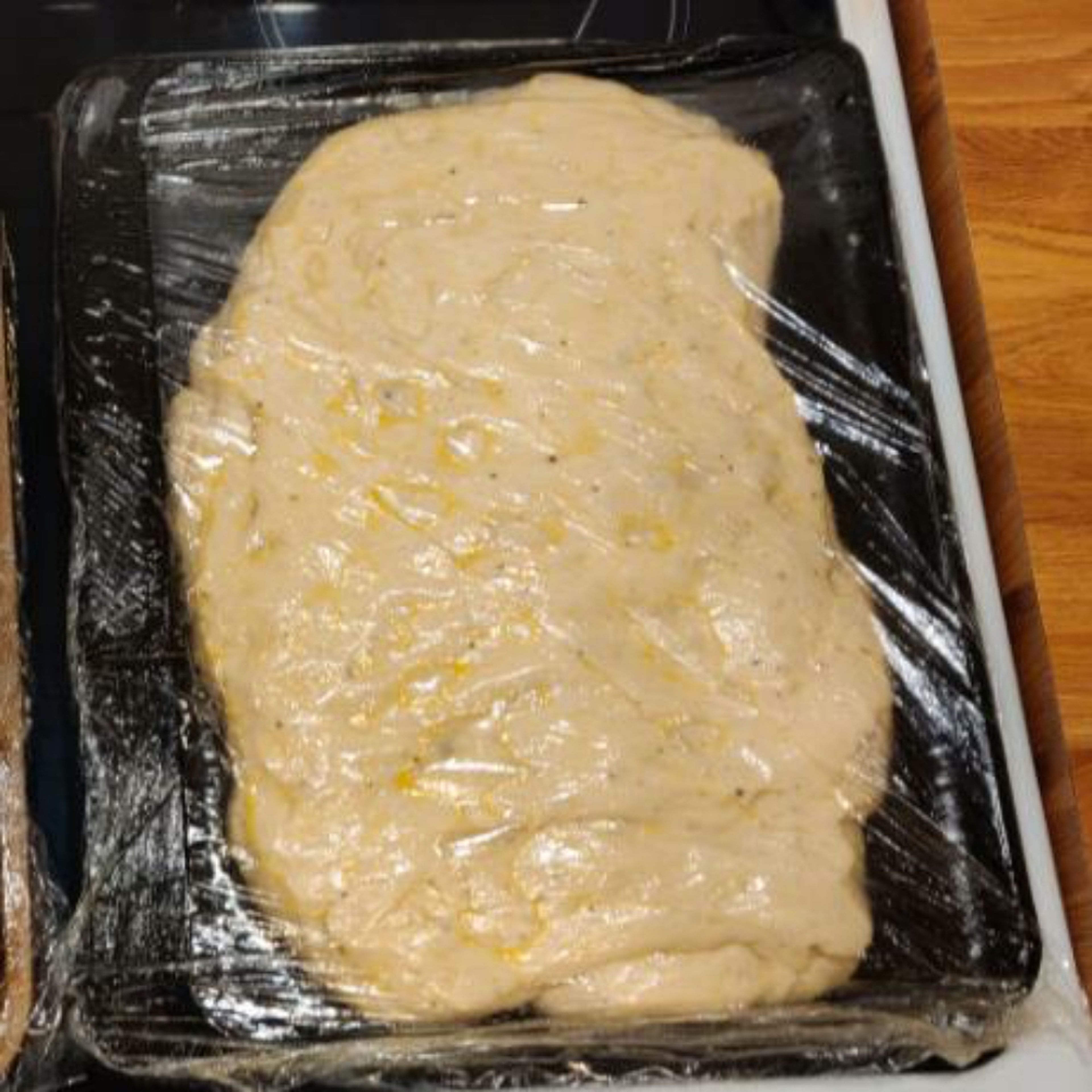 knock back the dough and place the dough into a well oiled baking sheet. stretch the dough to fit as much of the baking sheet as you can, but do not force it as this will get easier in the next step.