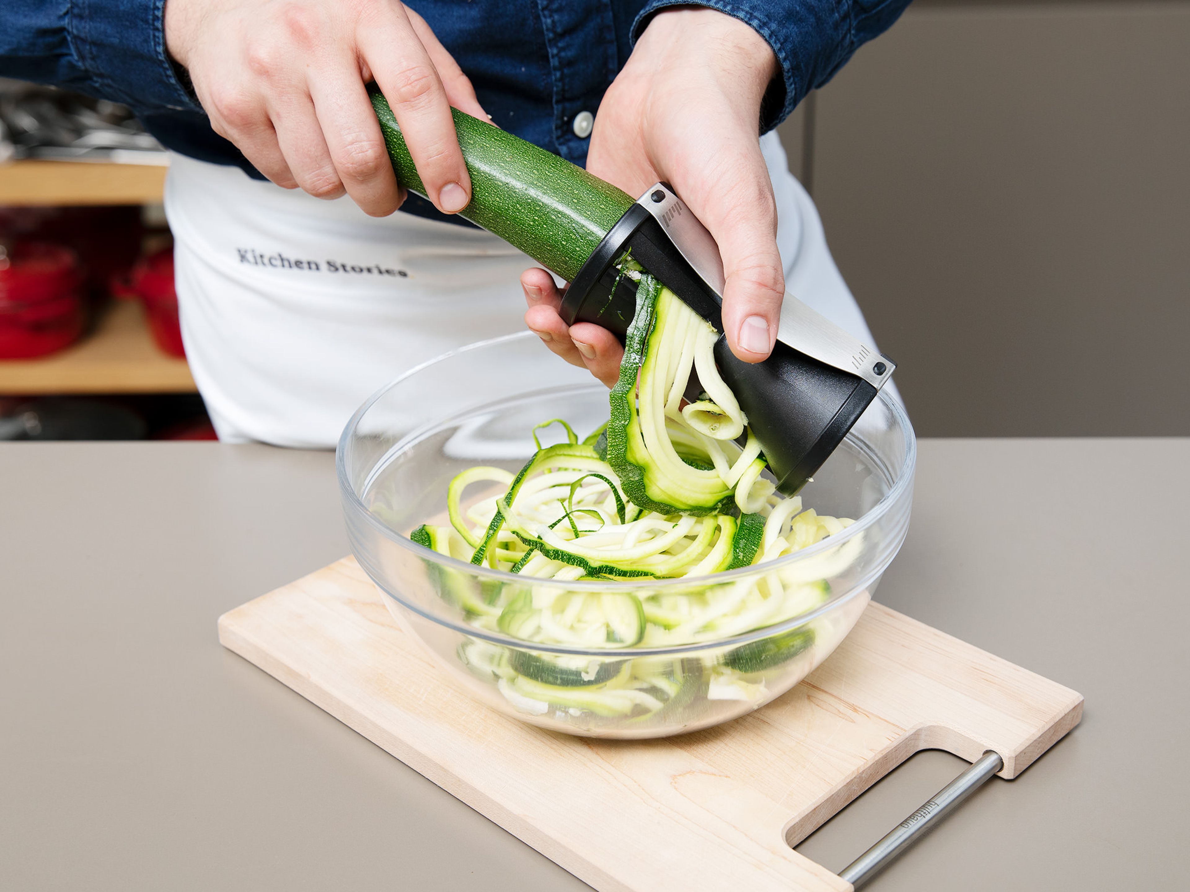 For the zoodles, trim the end off the zucchini and use a spiralizer to create zucchini noodles. Zest lime and juice. Thinly slice chili pepper, peel garlic and ginger, and chop roasted peanuts and cilantro. Heat some toasted sesame oil in a frying pan and fry the zoodles for approx. 10 min, tossing often. Season with salt and pepper, then set aside.