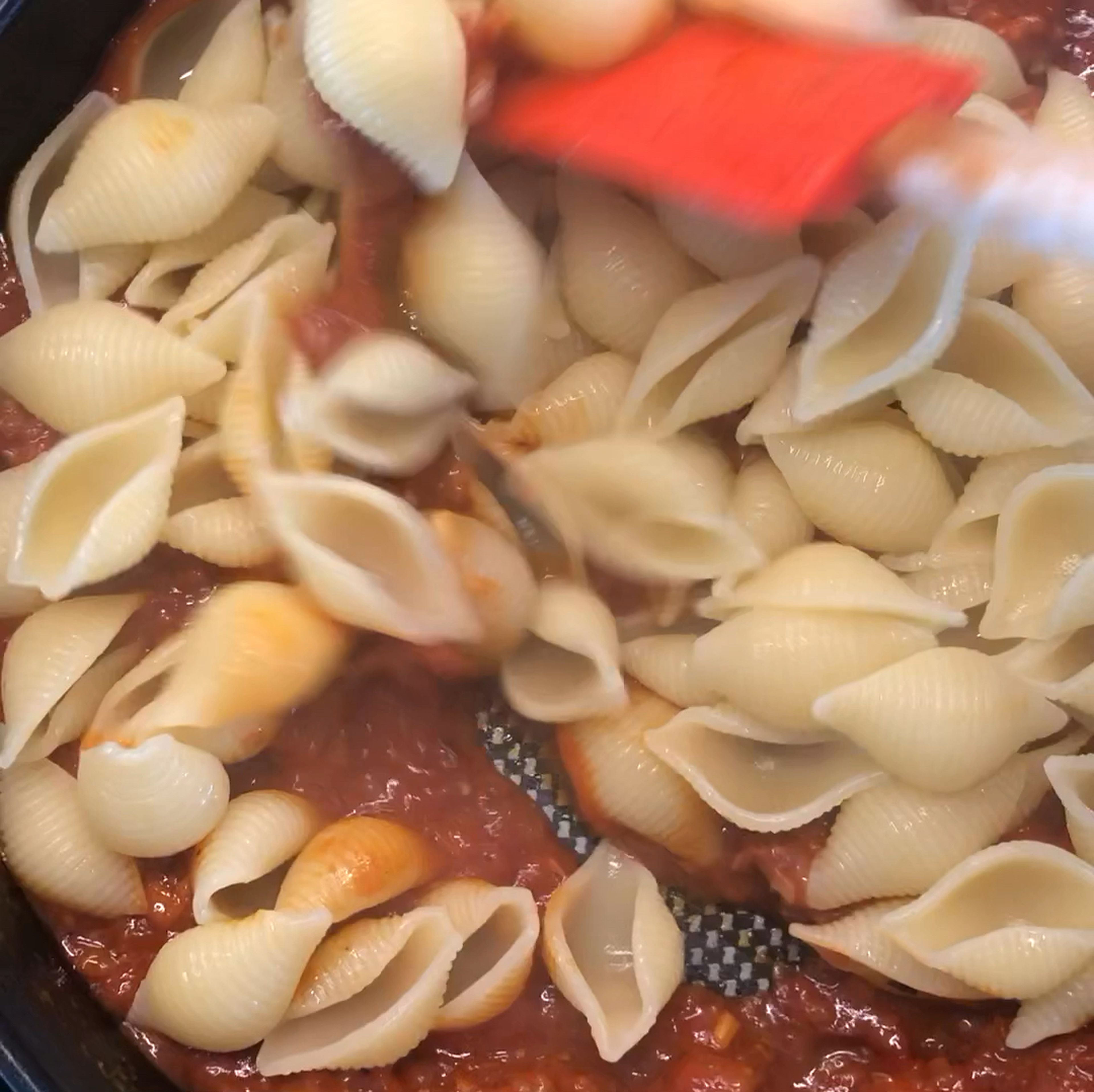 Soße vom Herd nehmen. Parmesan unterrühren und Nudeln hinzugeben. Nach Bedarf die Soße mit Nudelwasser auflockern.