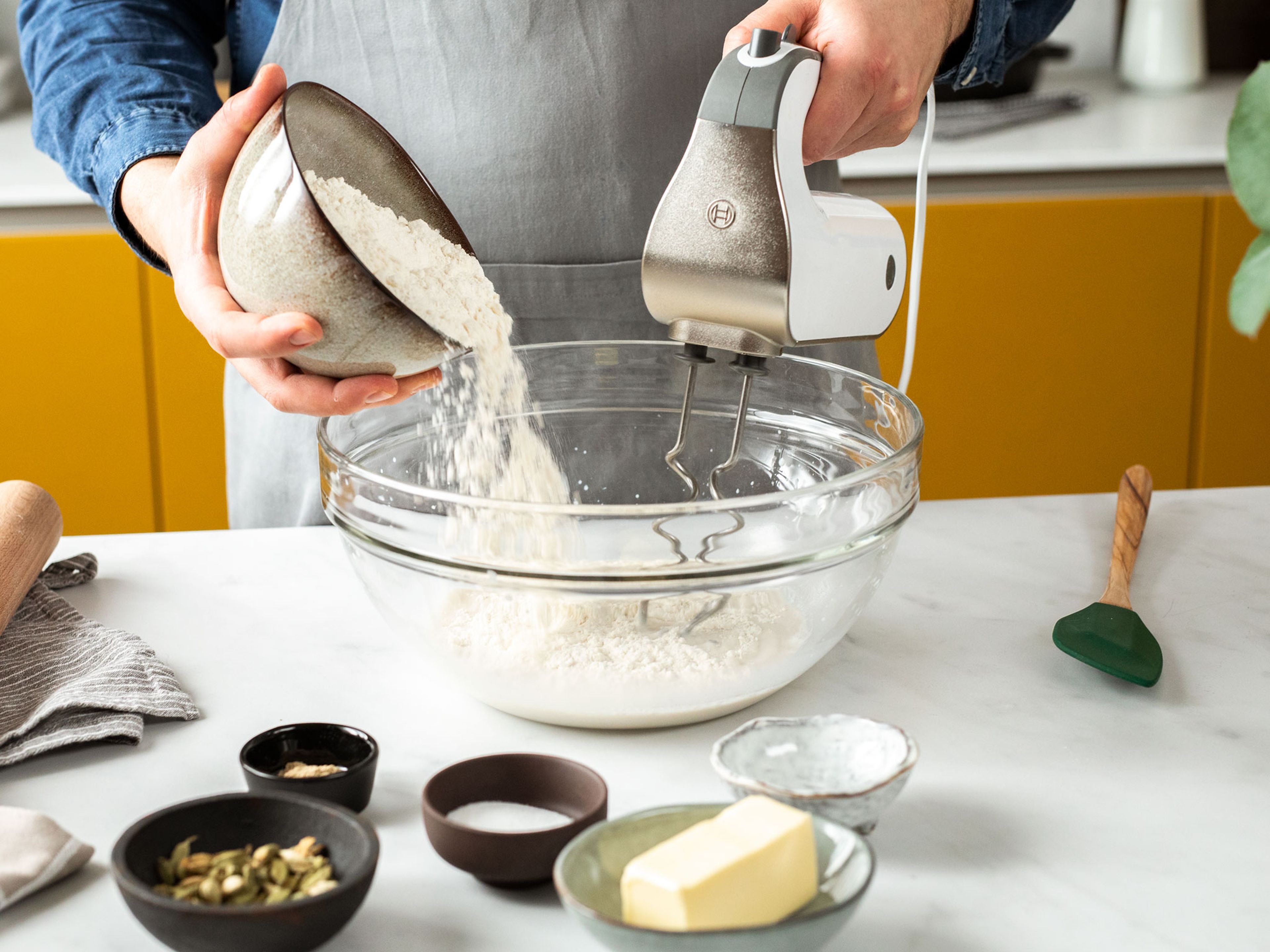 Whisk together the fresh yeast and lukewarm milk in a bowl. Add the flour, sugar, salt, some of the butter, and some of the ground cardamom and beat together using a hand mixer fitted with dough hooks. Cover with a clean kitchen towel and let rest for approx. 30 min.