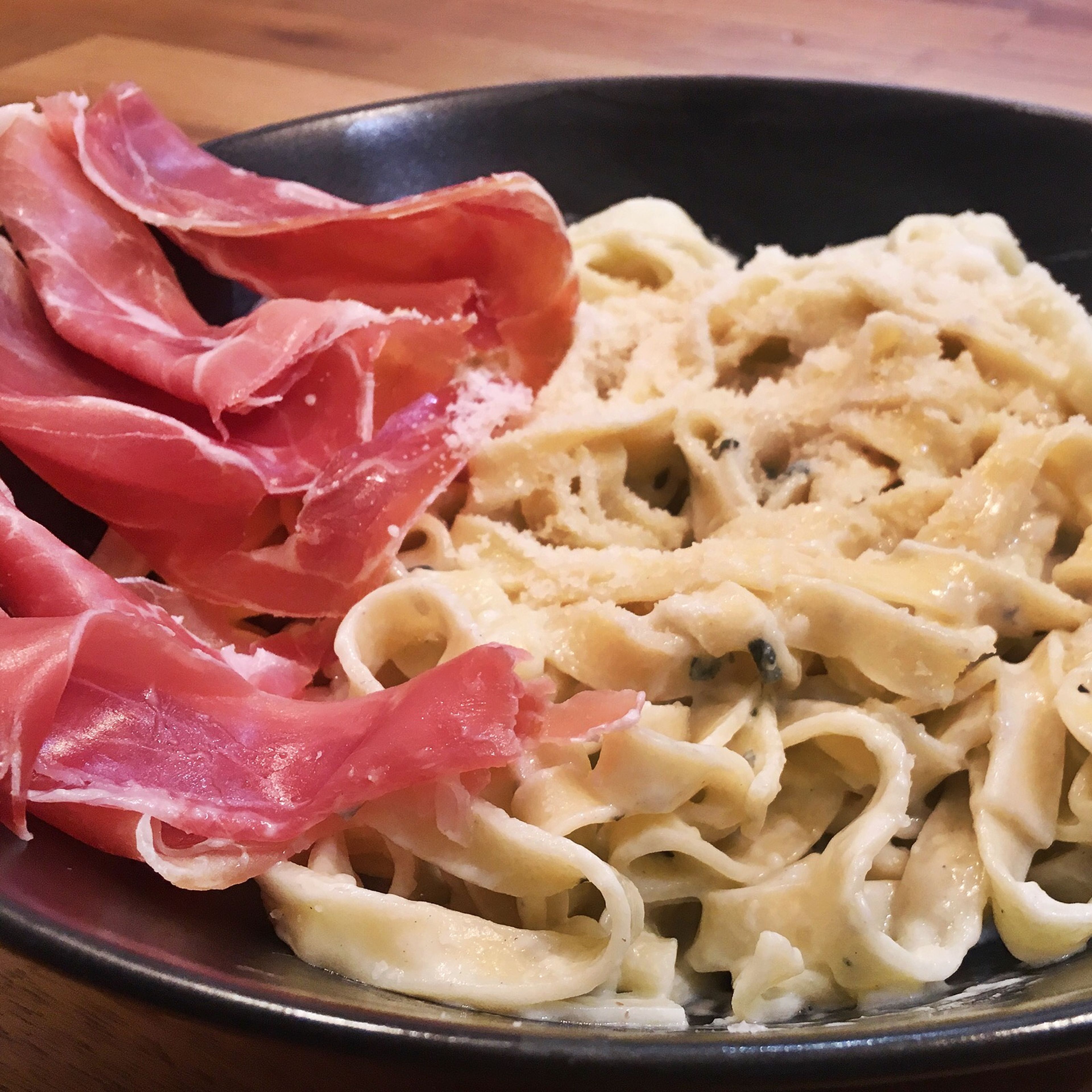 Pour the drained pasta into the cheese sauce and serve it in the plates. Then add some slices of Serrano ham and the crushed nuts. Enjoy!