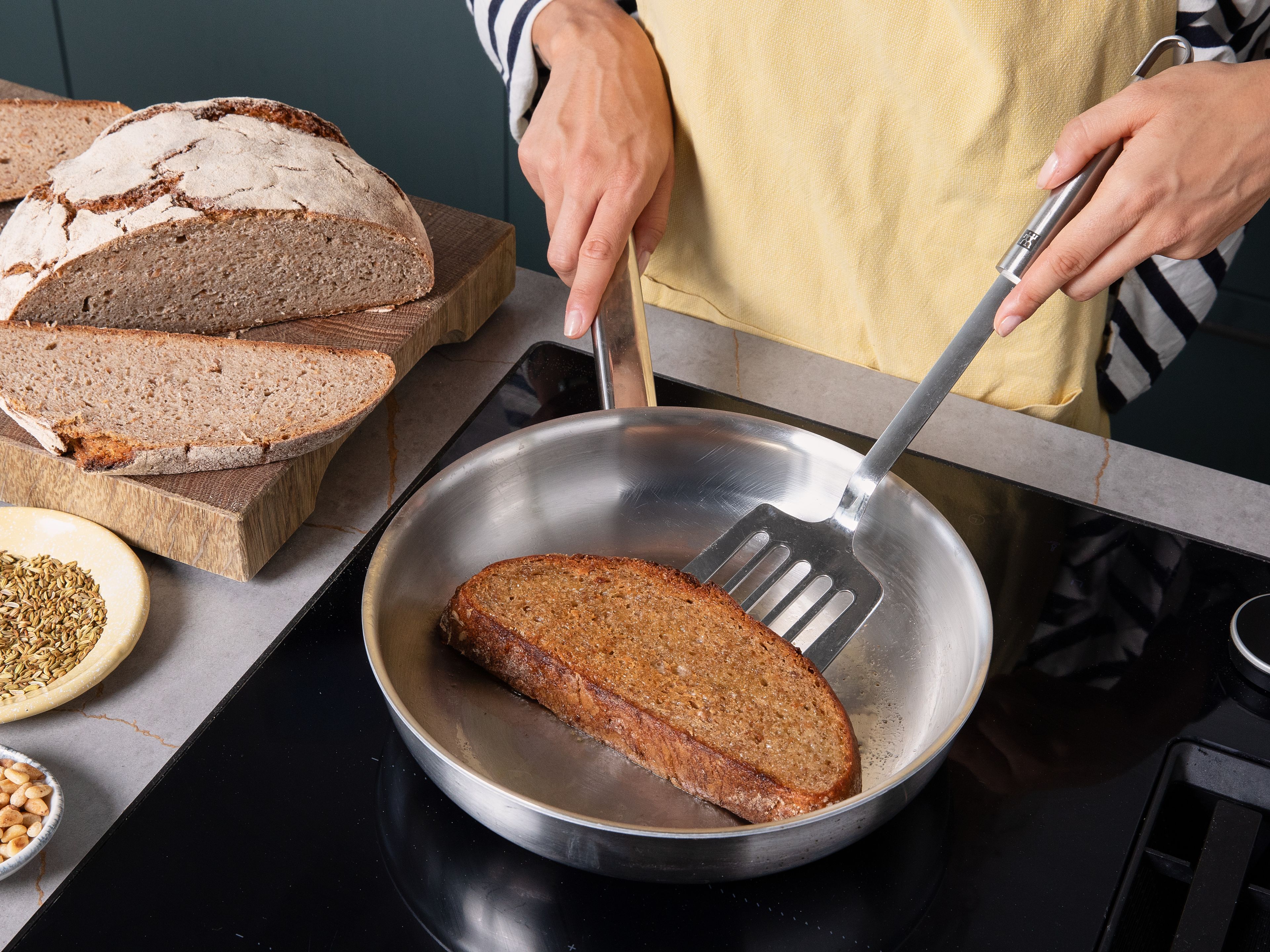Slice the bread and wash the salad thoroughly. Toast the pine nuts in a dry pan until golden, then remove and set aside. In the same pan, briefly toast the fennel seeds, then crush them using a mortar and pestle and set aside. Add a little olive oil to the pan and toast the bread slices on both sides for approx. 2 min. until golden and crisp.
