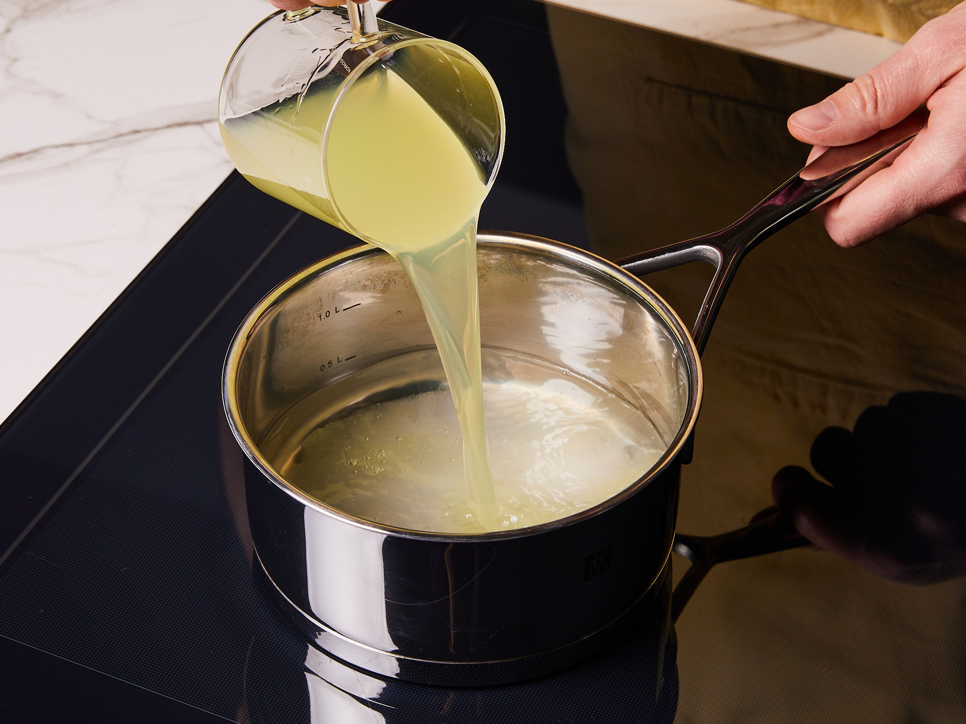 Für das Zitronen-Tiramisu mit dem Sirup beginnen und Limoncello, Zucker und Wasser in einem Topf zum Kochen bringen. Ca. 2 Min. leicht köcheln lassen, bis sich der Zucker auflöst und der Alkohol verdampft. In eine Schüssel umfüllen und beiseitestellen.
