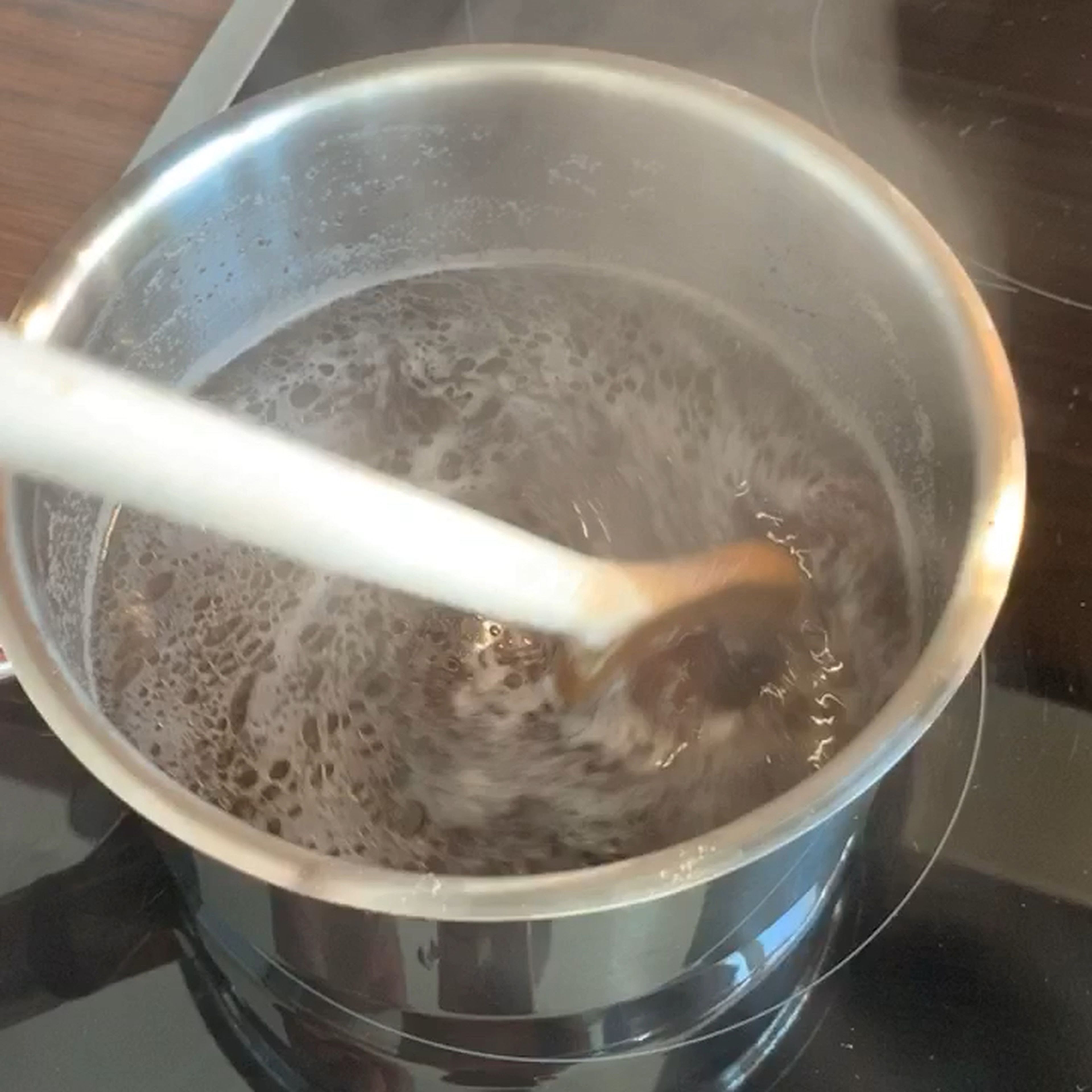 Den Sud aus dem Vakuumbeutel durch ein Sieb passieren und in einem Topf mit dem Kalbsfonds aufkochen