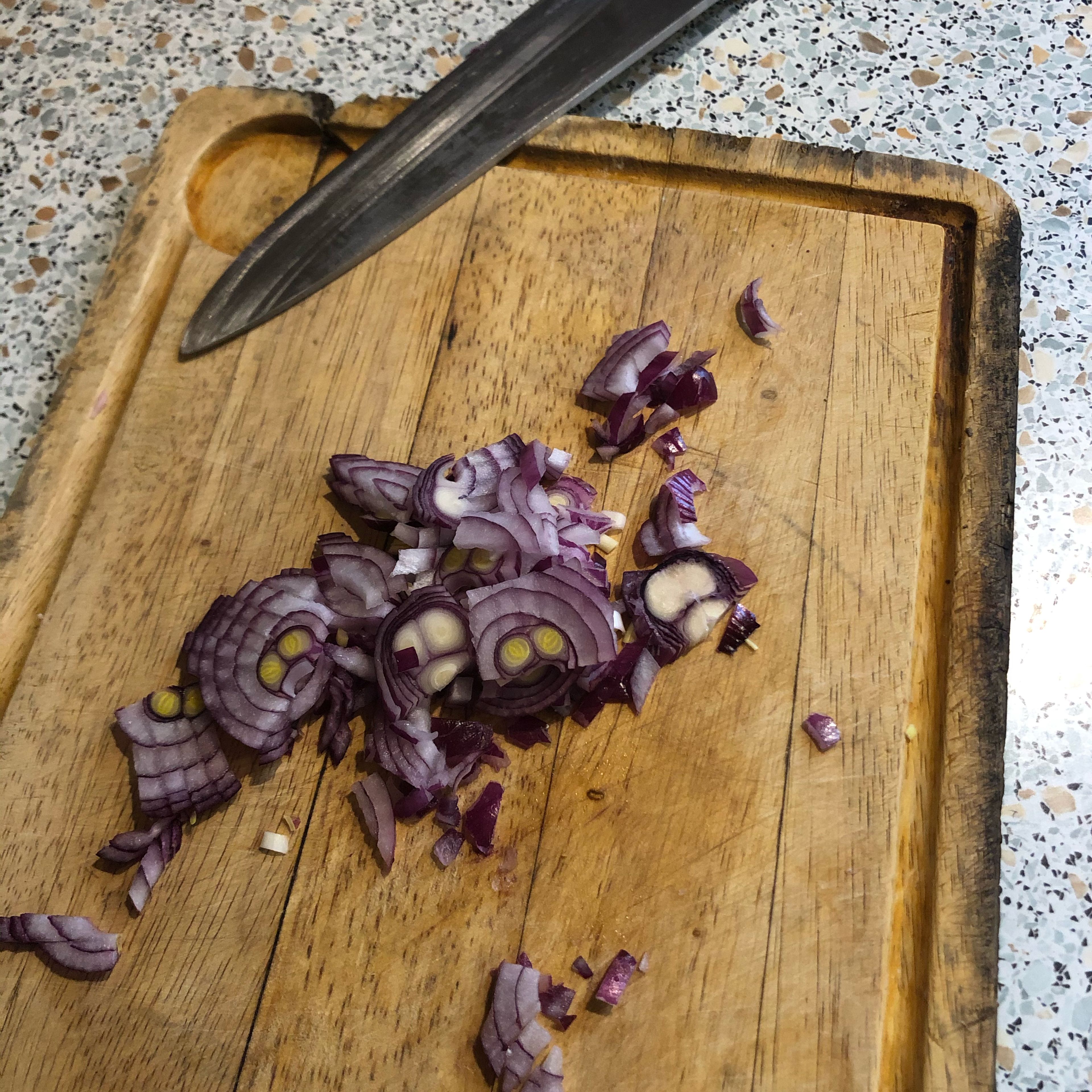 Der zweite Schritt zum leckeren Wurstsalat ist, das Würfelschneiden des Zwiebels.