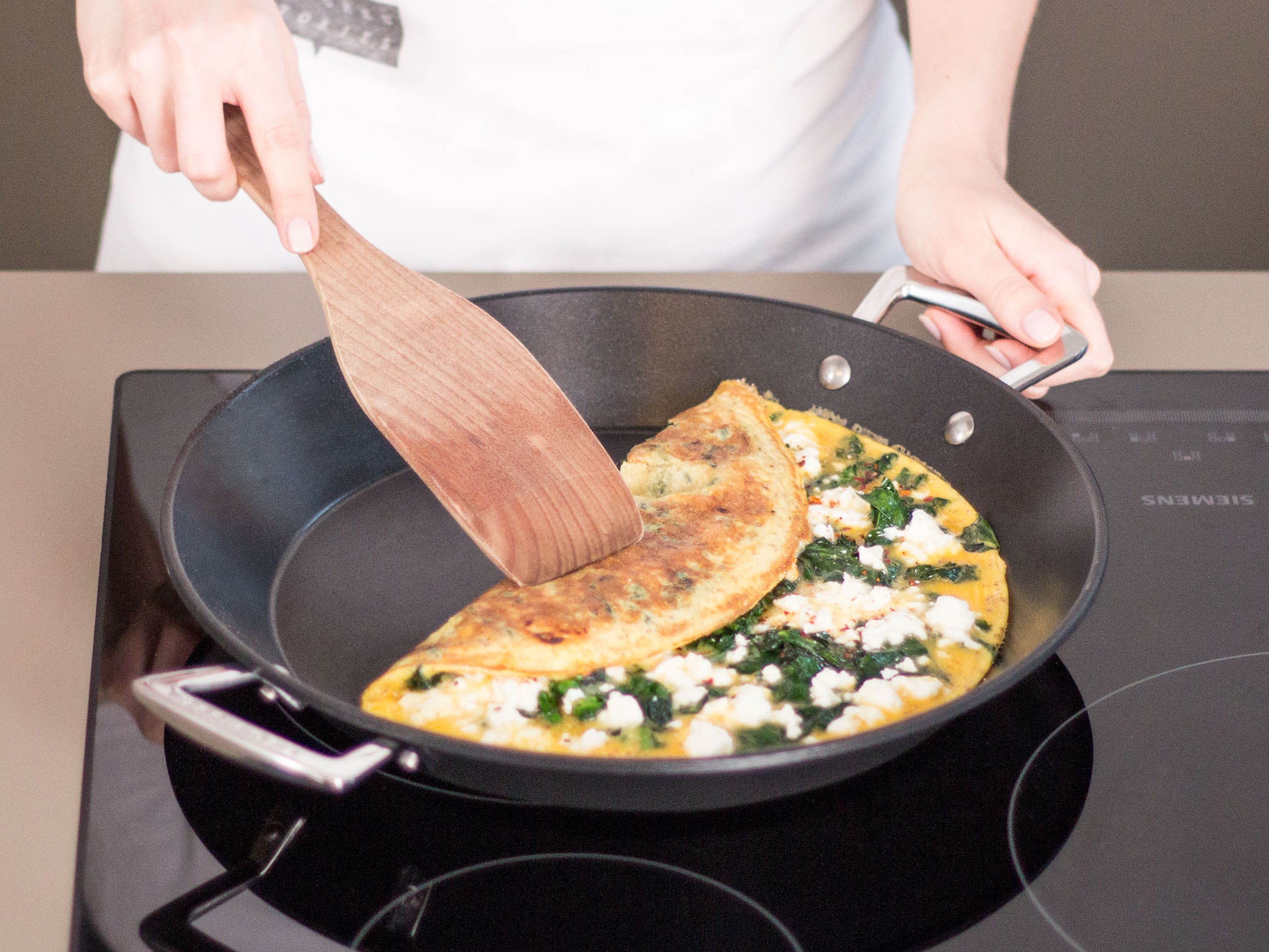 Eine Hälfte des Omeletts auf die andere klappen und weiterbraten, bis die Eier komplett gestockt sind, danach warm servieren. Guten Appetit!
