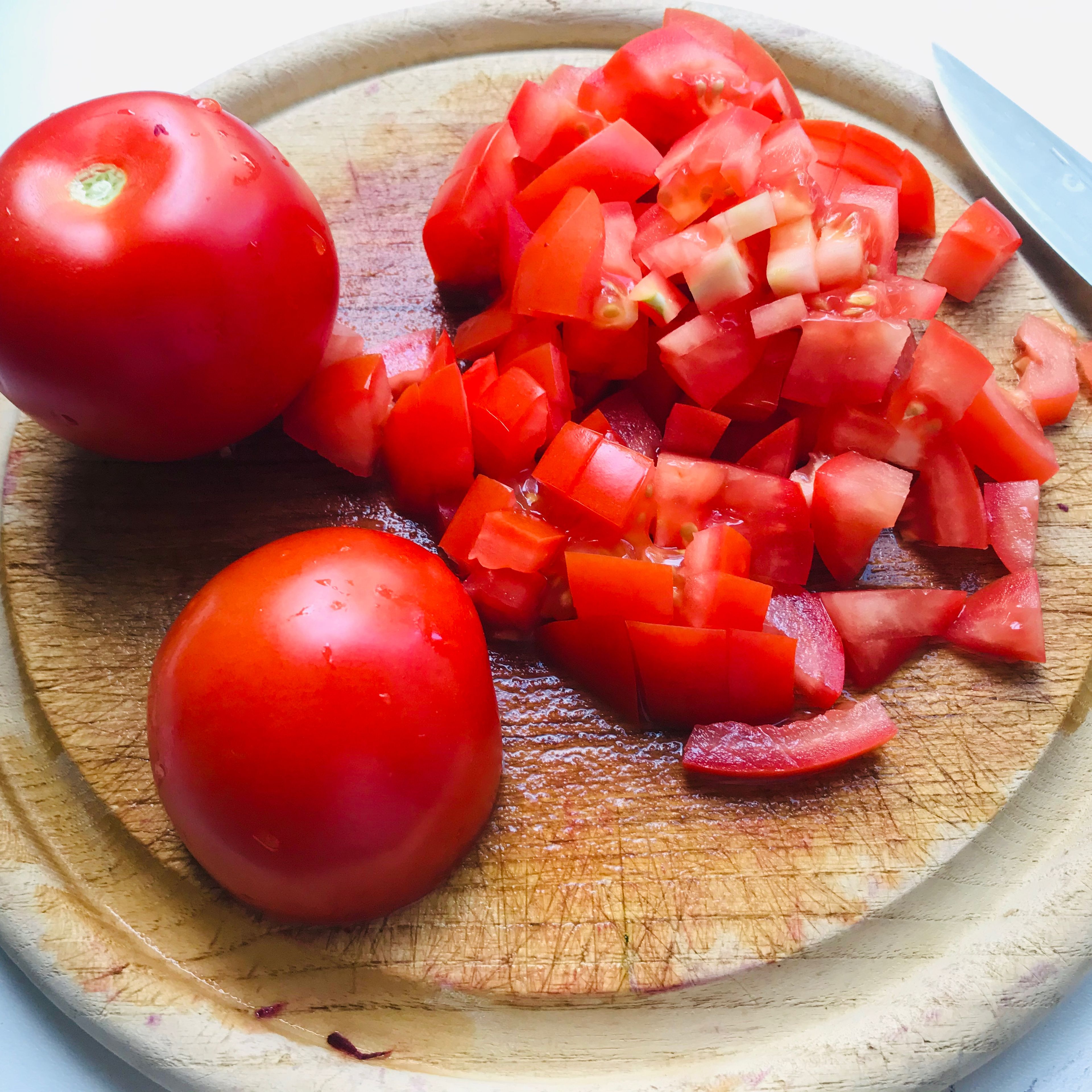 Währenddessen die Tomaten in Würfel schneiden.