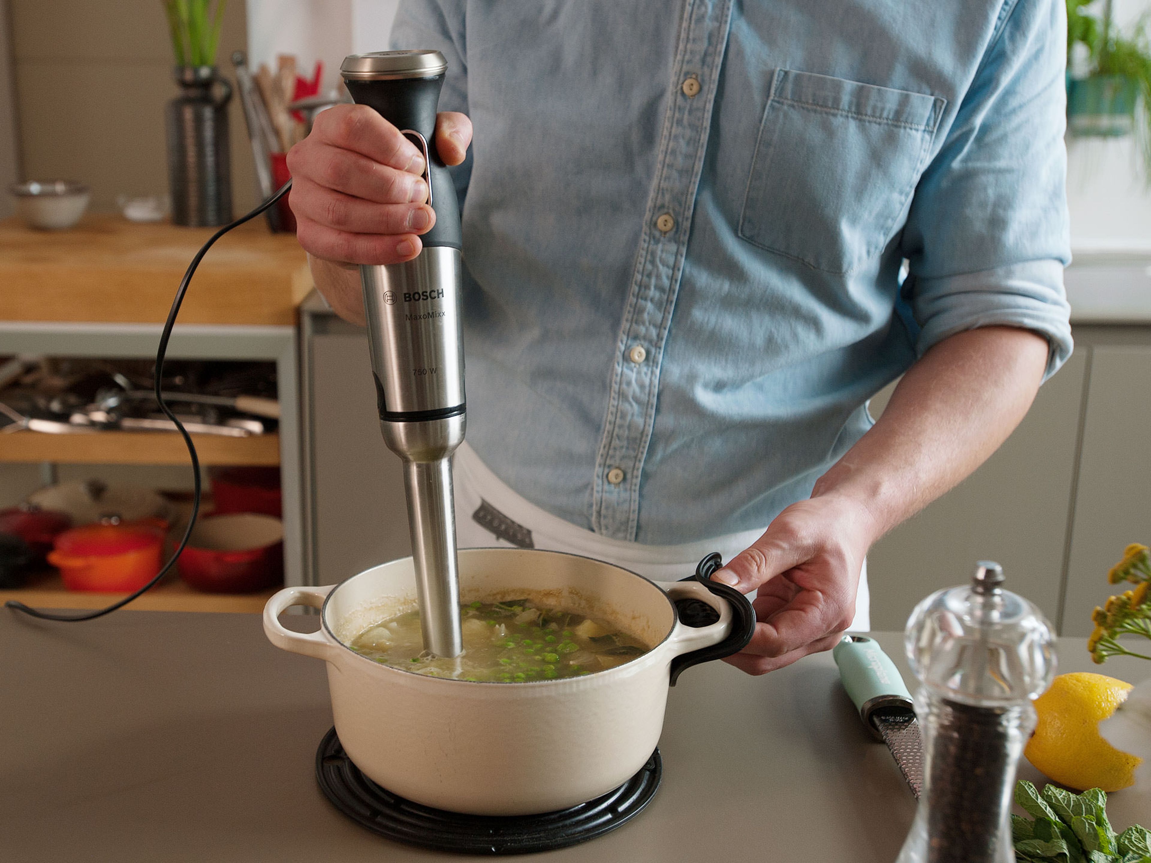 Deglaze with vegetable stock, bring to a boil, then reduce heat and let simmer for approx. 10 – 15 min., until potatoes are cooked through. Add remaining frozen peas. Remove from heat and purée with a hand blender.