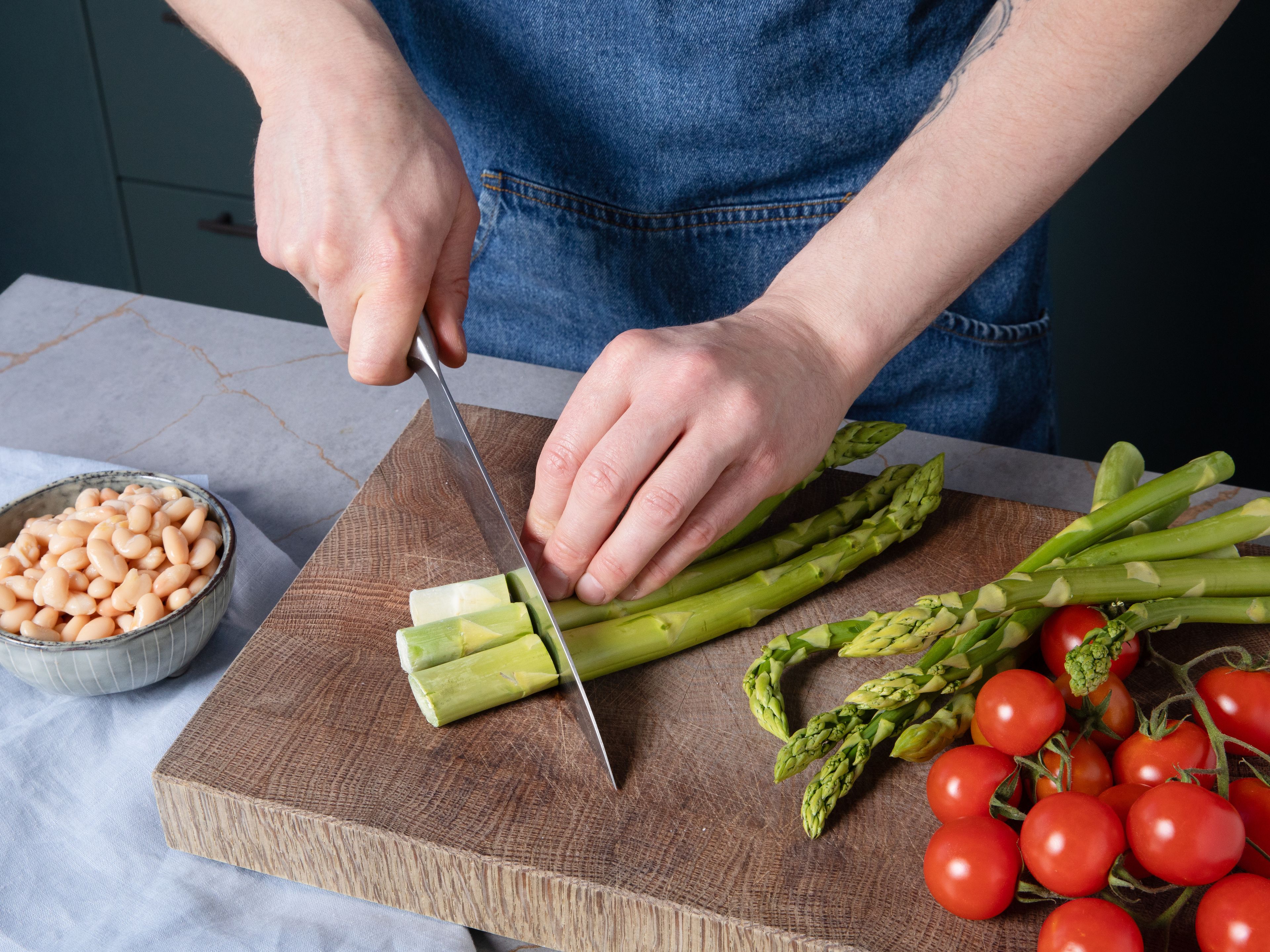 Wash green asparagus, trim off the woody ends, and cut into bite-sized pieces. Halve cherry tomatoes. Rinse and drain white beans well. Heat some olive oil in a pan and sauté asparagus over medium heat for approx. 4–5 min. Add beans and cook for approx. 2 more min. Season with salt and pepper, then remove from the pan and set aside.
