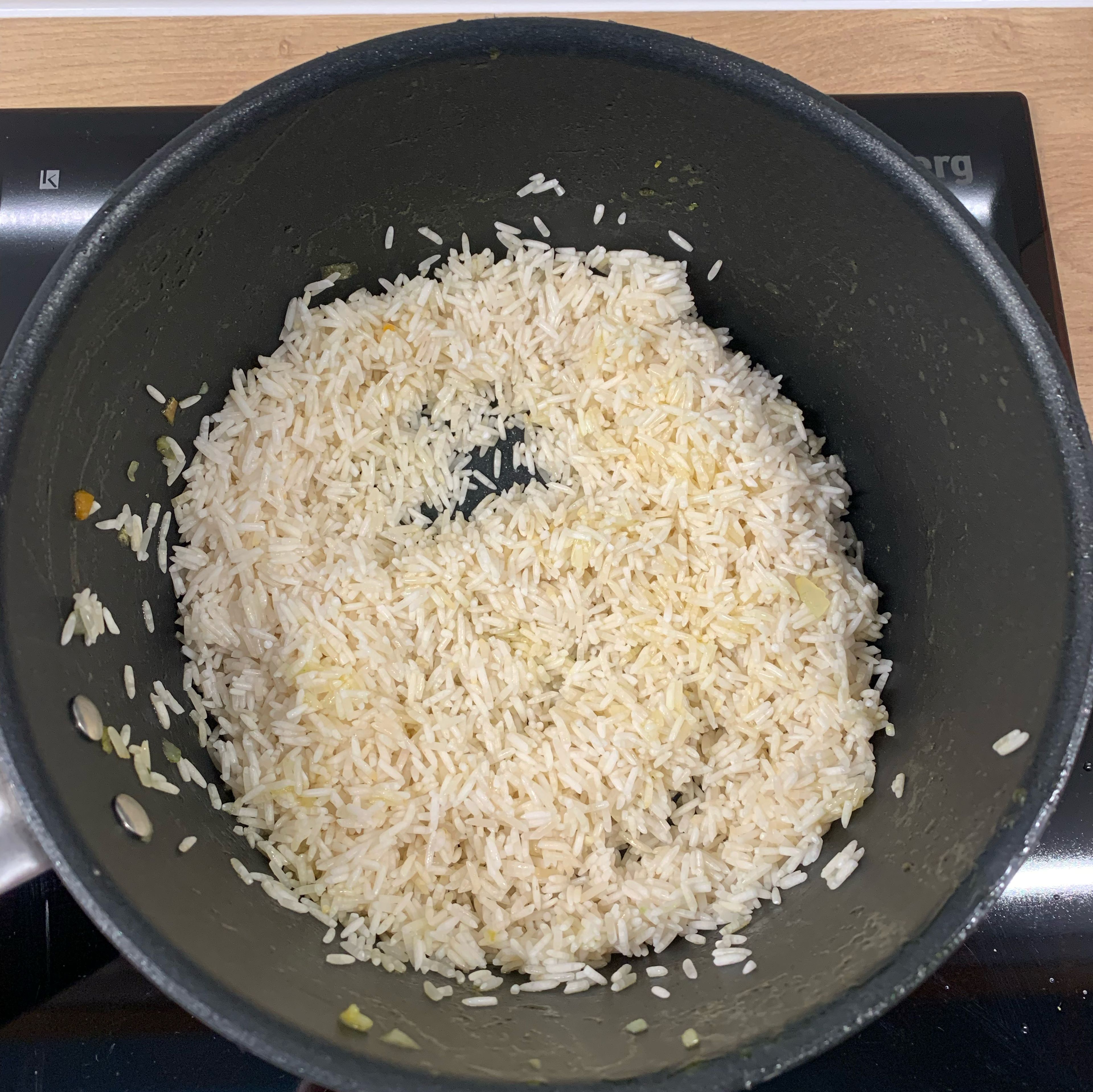 Den Reis waschen und In dem selben Topf etwas Öl erhitzen. Den Reis kurz darin anbraten und die Brühe von dem Gemüse mit Wasser verlängern so das es die eineinhalbfache Menge vom Reis ergibt. Den Reis damit ablöschen. Den Reis nun köcheln lassen