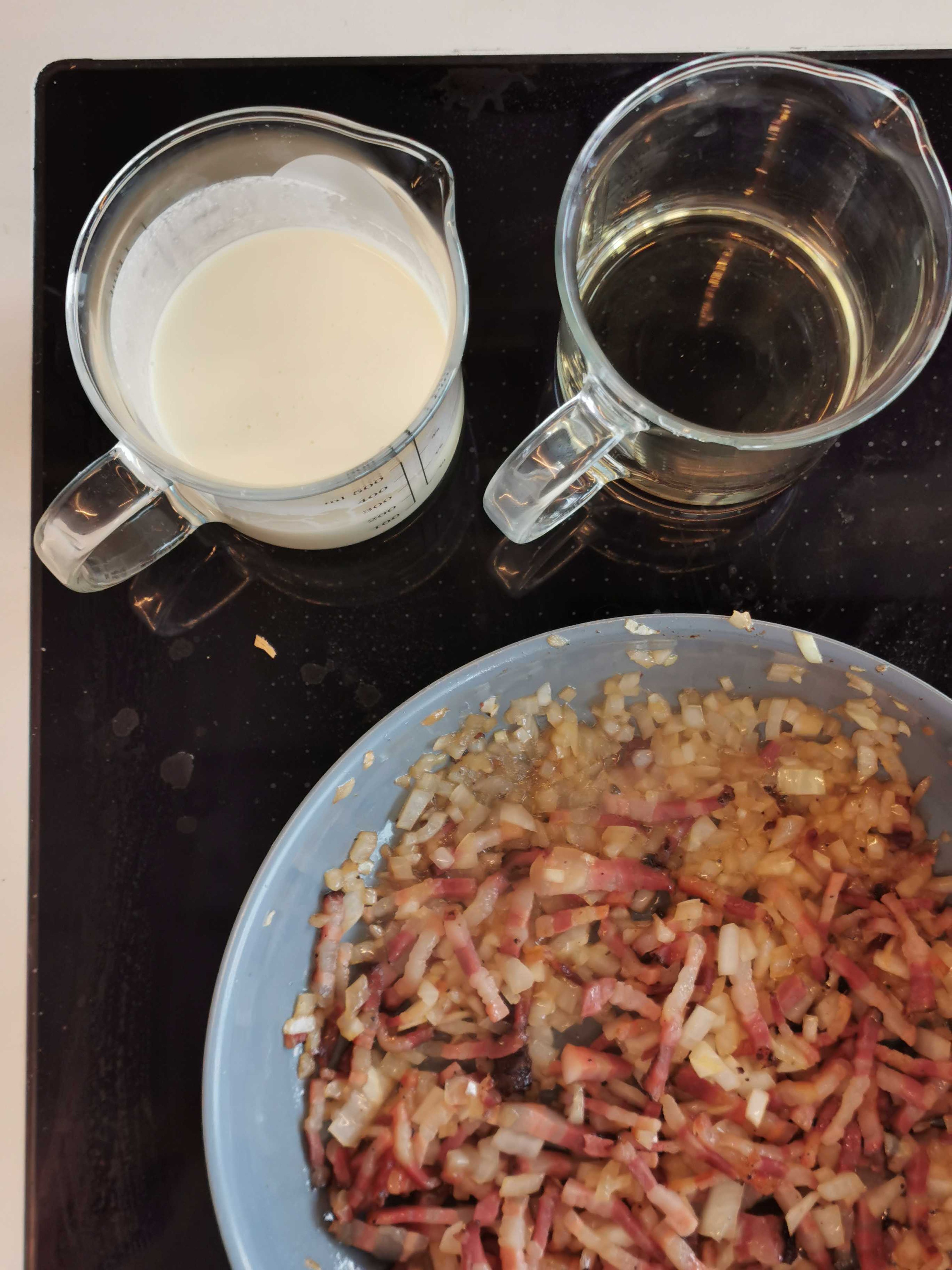 Peel and dice onions. Dice smoked bacon and fry in a pan. Slightly braise the onions in the same pan. Deglaze with heavy cream and season to taste.