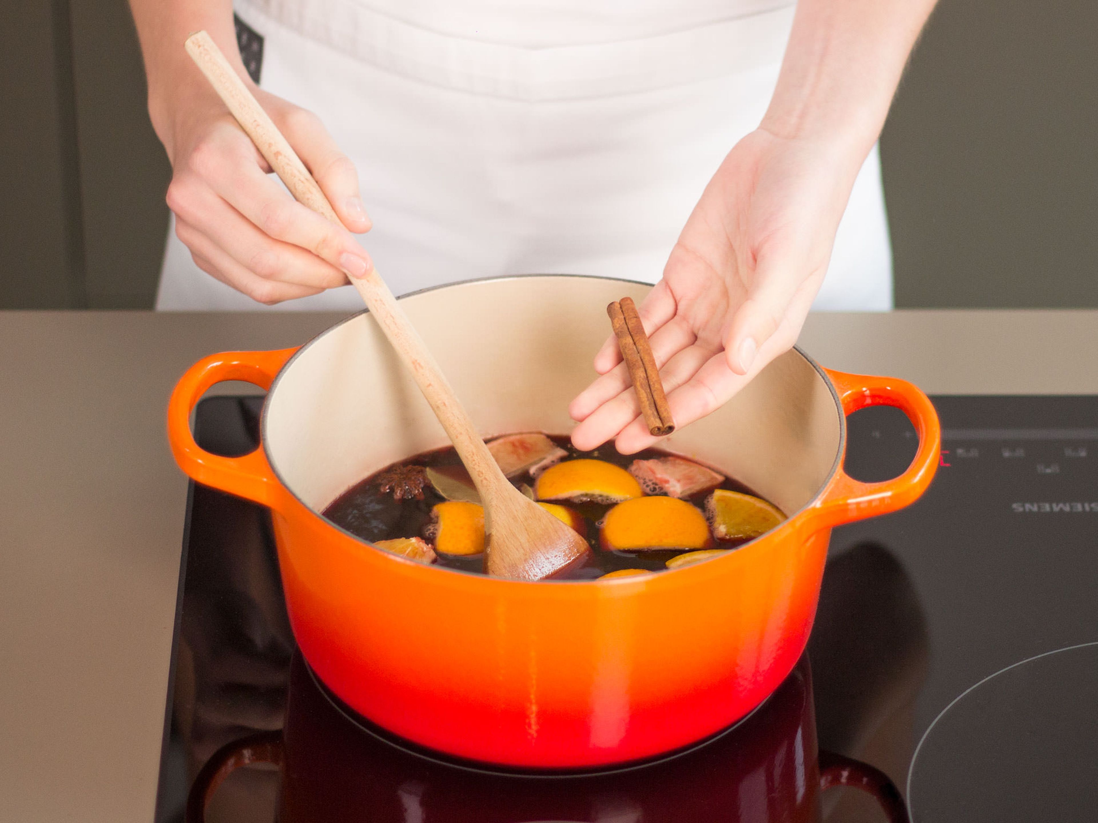 Orangen- und Zitronenstücke, Nelken, Lorbeerblatt, Sternanis, Wacholderbeeren und Zimt hinzugeben. Aufkochen lassen und bei niedriger Hitze ca. 10 – 15 Min. köcheln lassen.