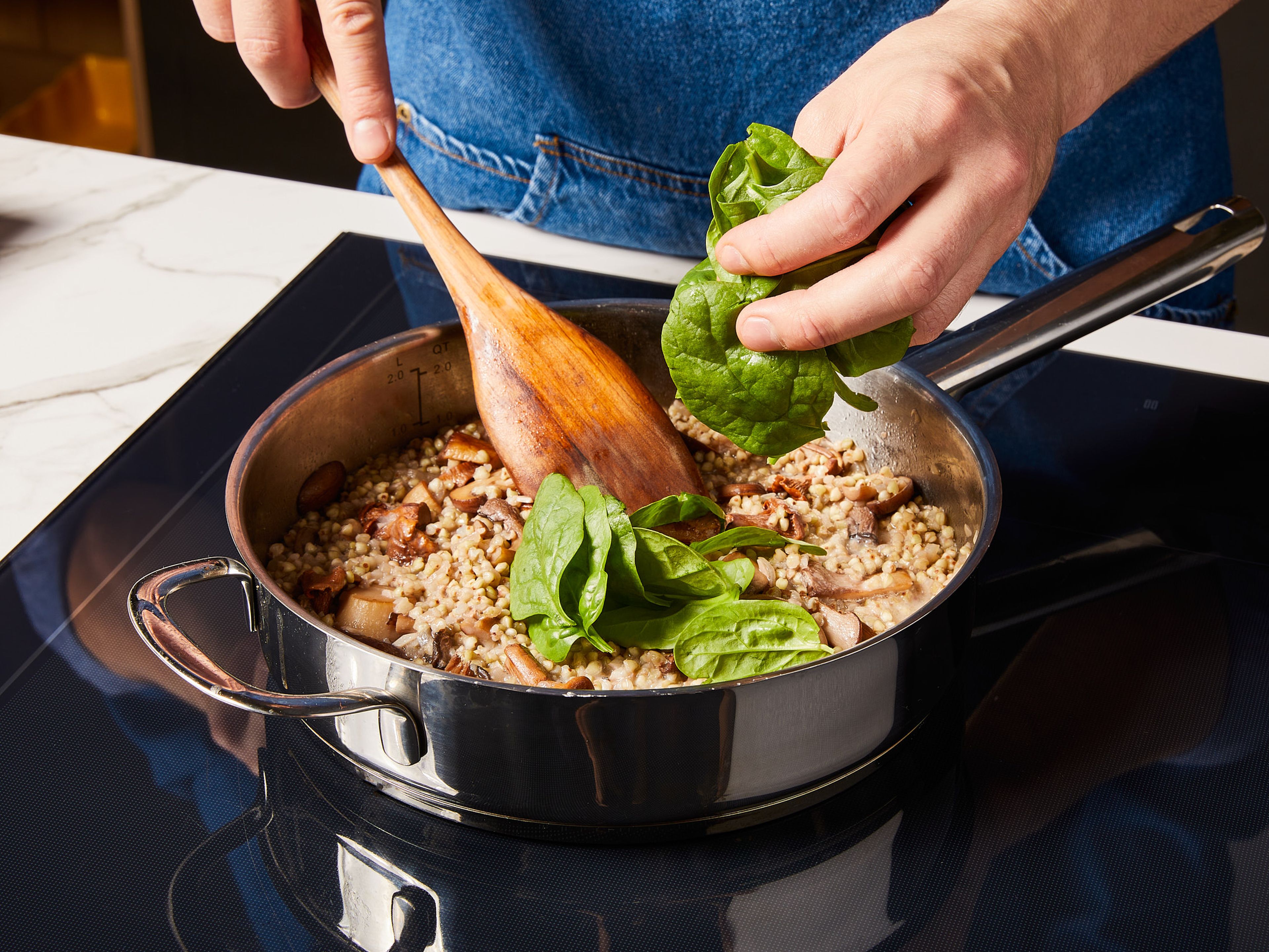 Zuletzt den frischen Spinat und die Cashew Milchalternative unter das Risotto rühren. Währenddessen die Petersilie fein hacken. Das Buchweizen-Risotto auf Tellern anrichten, mit den beiseitegestellten Pilzen, Kürbiskernen und Petersilie garnieren und servieren.