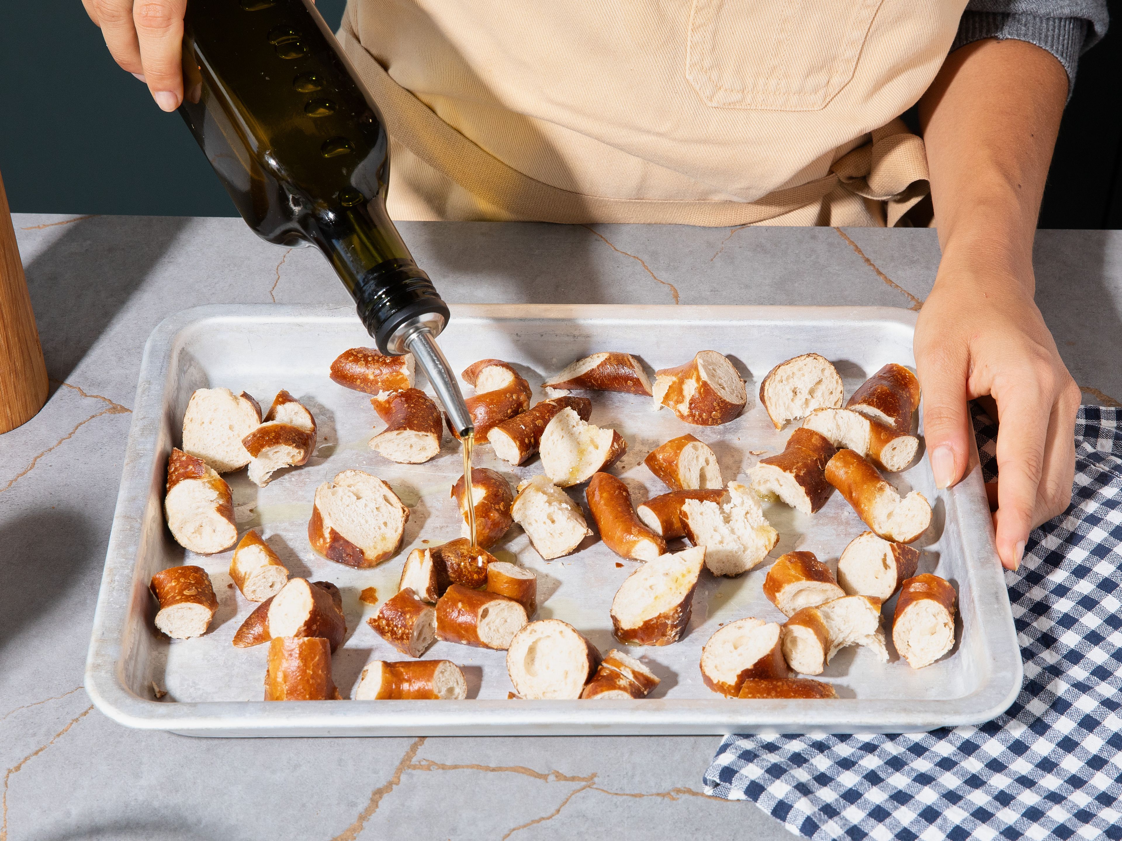 Preheat the oven to 180°C/356°F top/bottom heat. Cut pretzels into large pieces, arrange on a baking sheet, drizzle with some olive oil, and season with salt and pepper. Transfer to the oven and roast for approx. 15–20 min., until golden brown.