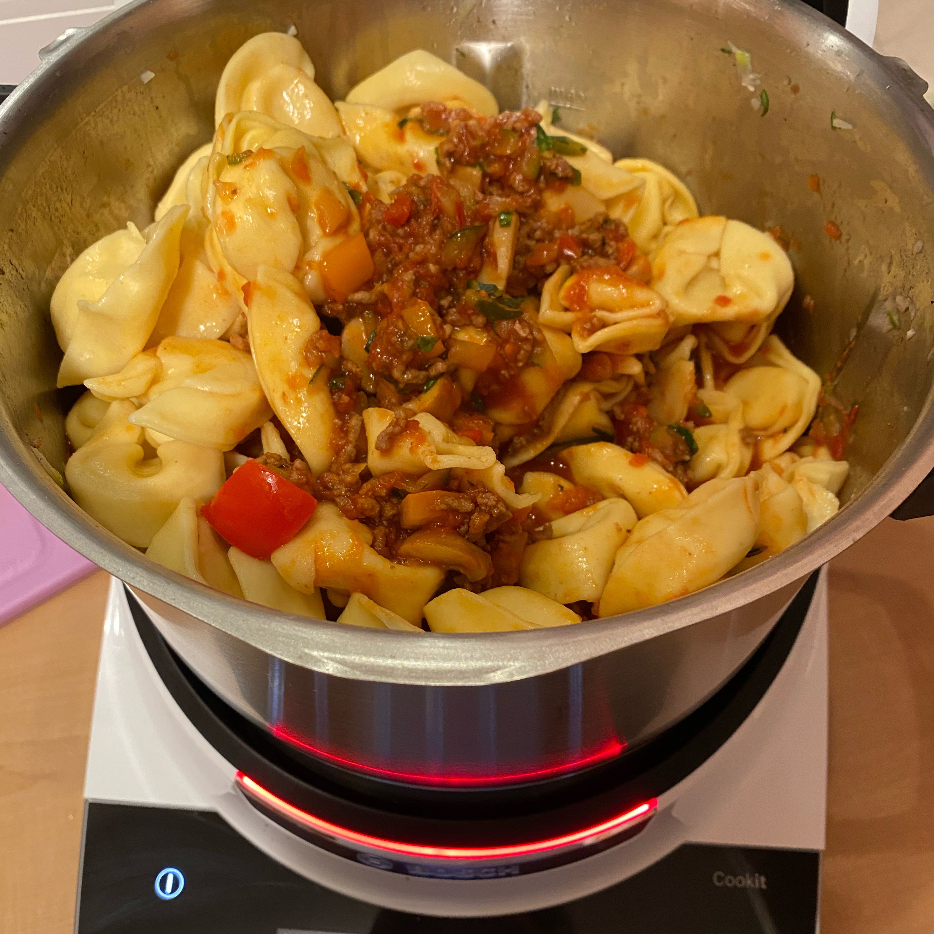 Tortellini in den Mixtopf geben und mit dem Küchenspatel mit der Soße vermischen.