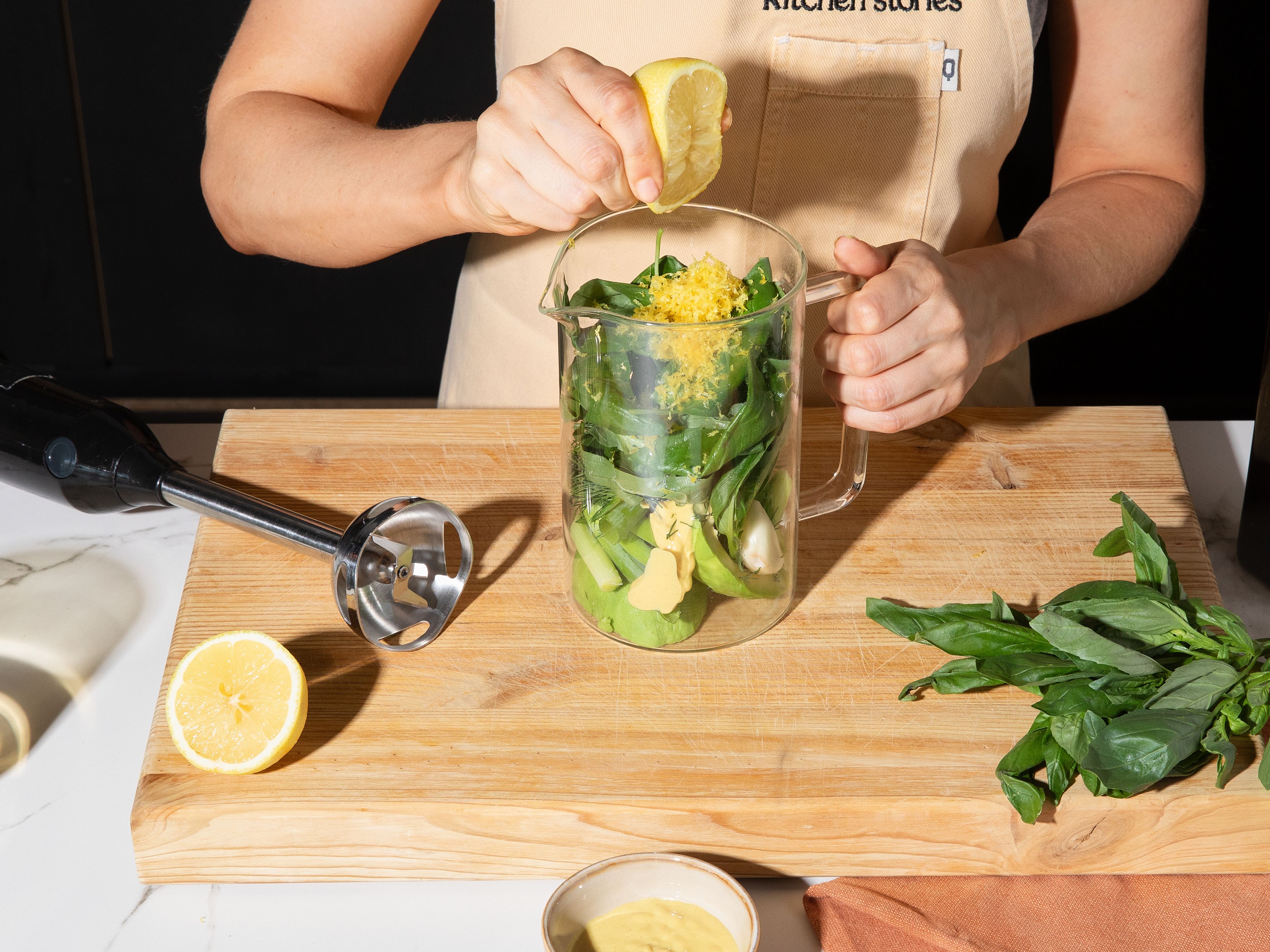 For the dressing, blend avocado, basil, dill, green onion, garlic clove, lemon juice, lemon zest, Dijon mustard, and olive oil in a blender or using an immersion blender until creamy. Season with salt and pepper to taste. If necessary, add a little water until dressing has a thick, creamy consistency. Mix cucumbers with dressing and add to plates or in a big bowl. Sprinkle with warm, crispy chickpeas, crumble feta on top, and garnish with additional herbs. Serve immediately.